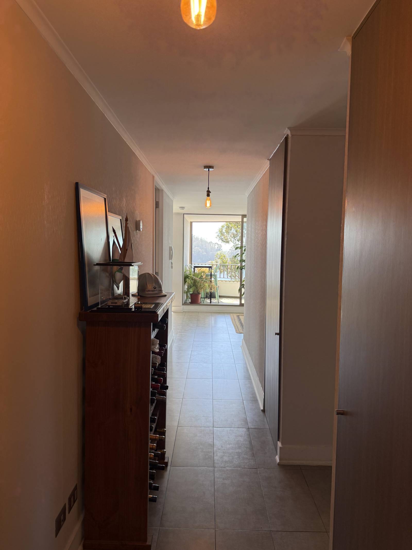 Pasillo de acceso con mueble botellero hacia los ambientes principales