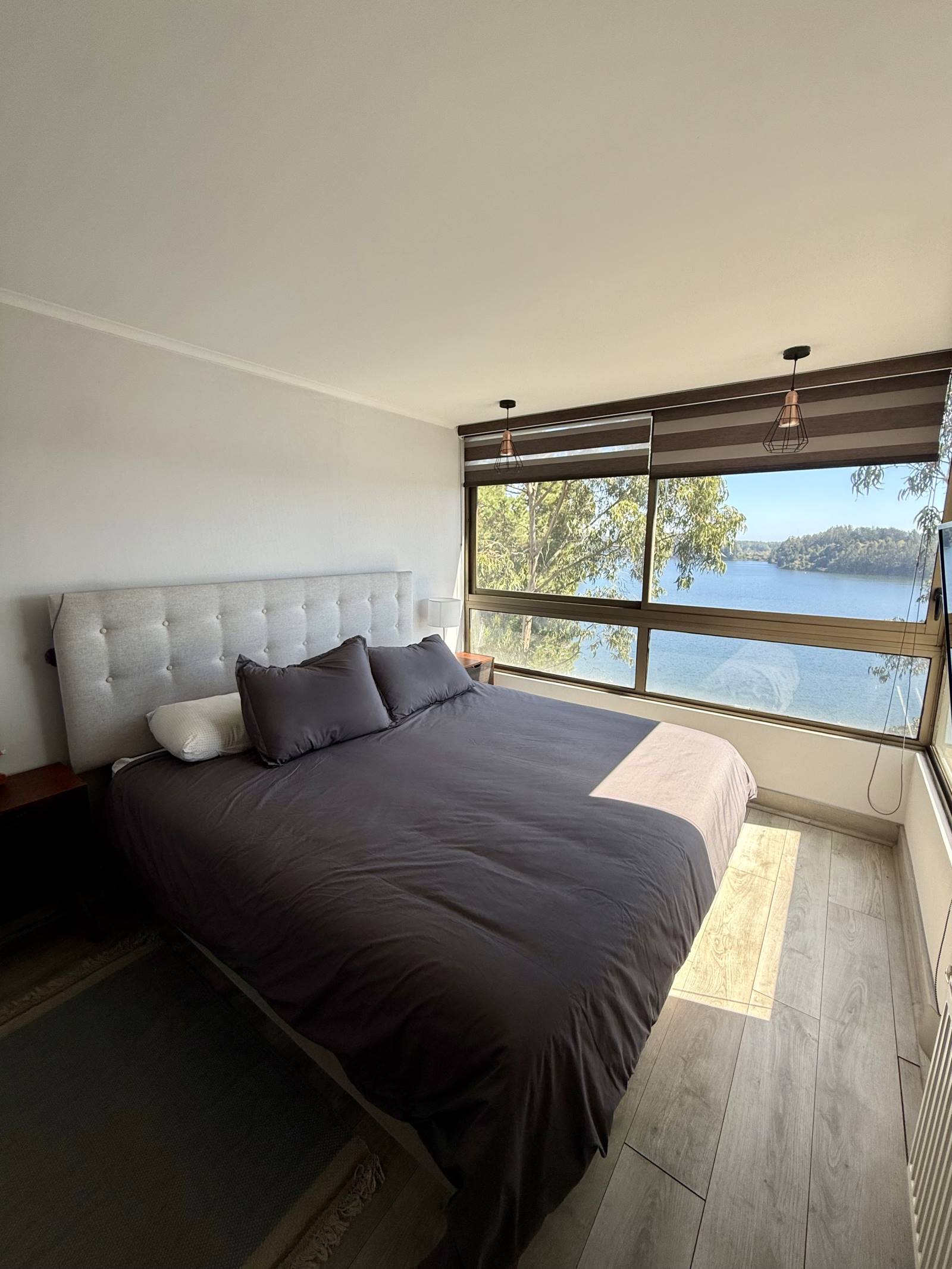 Dormitorio principal con cama matrimonial y ventanal con vista panorámica