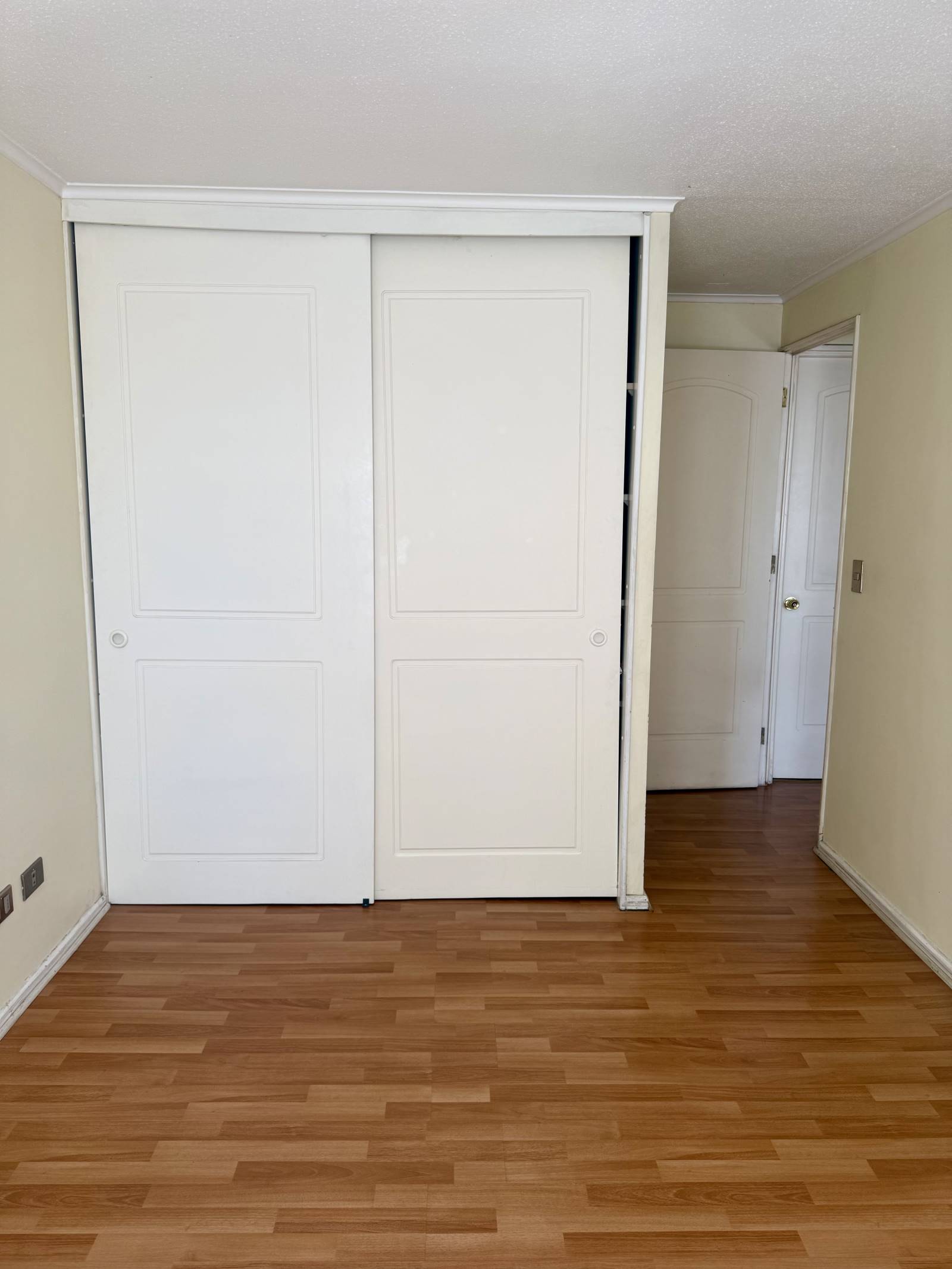 Clóset empotrado blanco de puertas correderas en dormitorio
