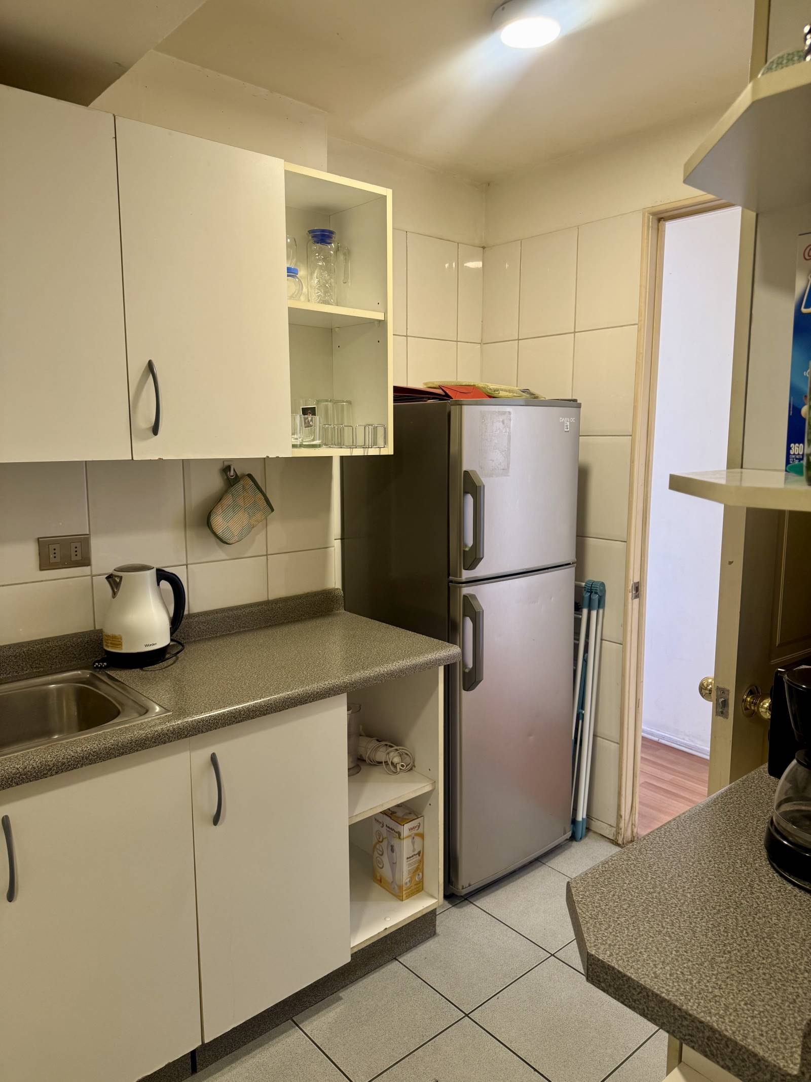 Mueble de cocina inferior y refrigerador en sector de servicio