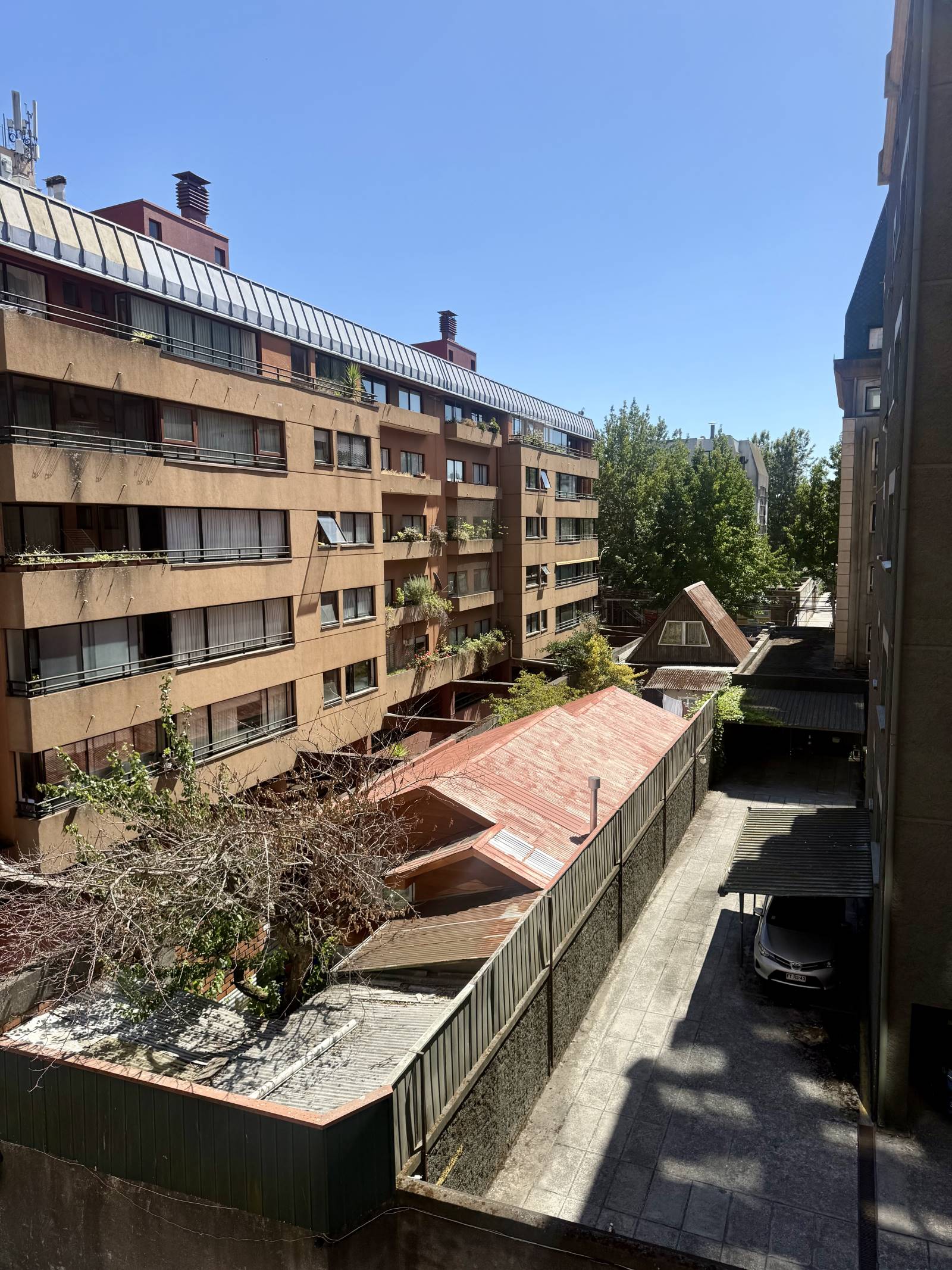 Vista despejada desde altura hacia patio interior y edificios vecinos
