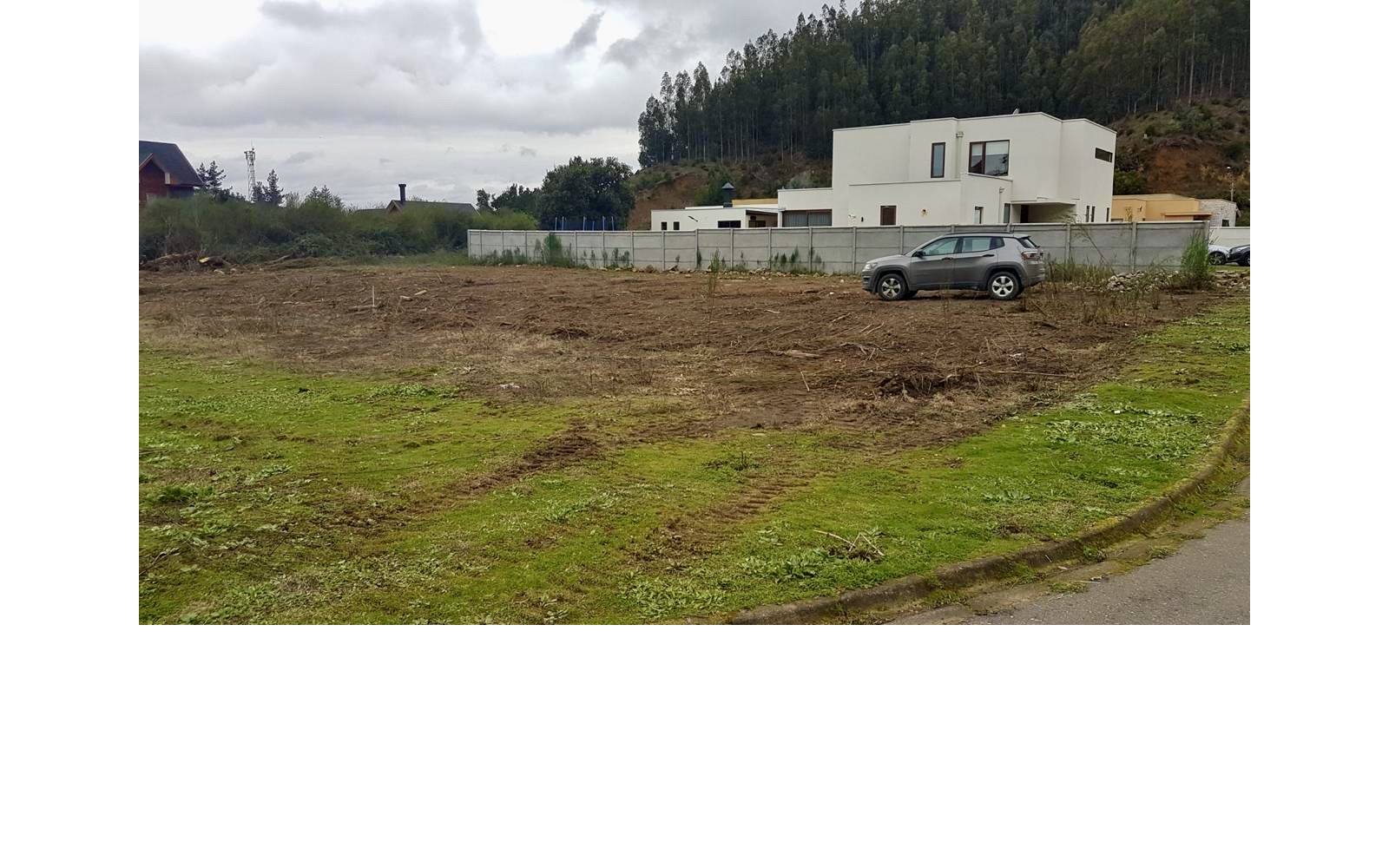 Sitio despejado a nivel de calle con casas colindantes
