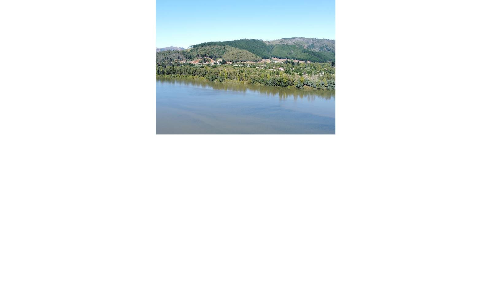 Vista panorámica del río y cerros boscosos en día despejado.
