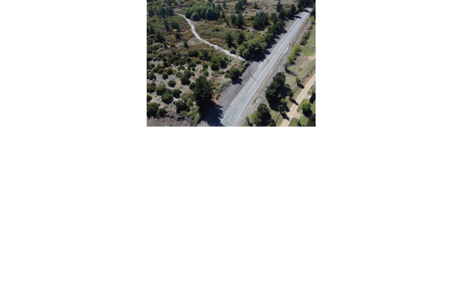 Vista aérea de acceso vial y entorno natural del terreno.