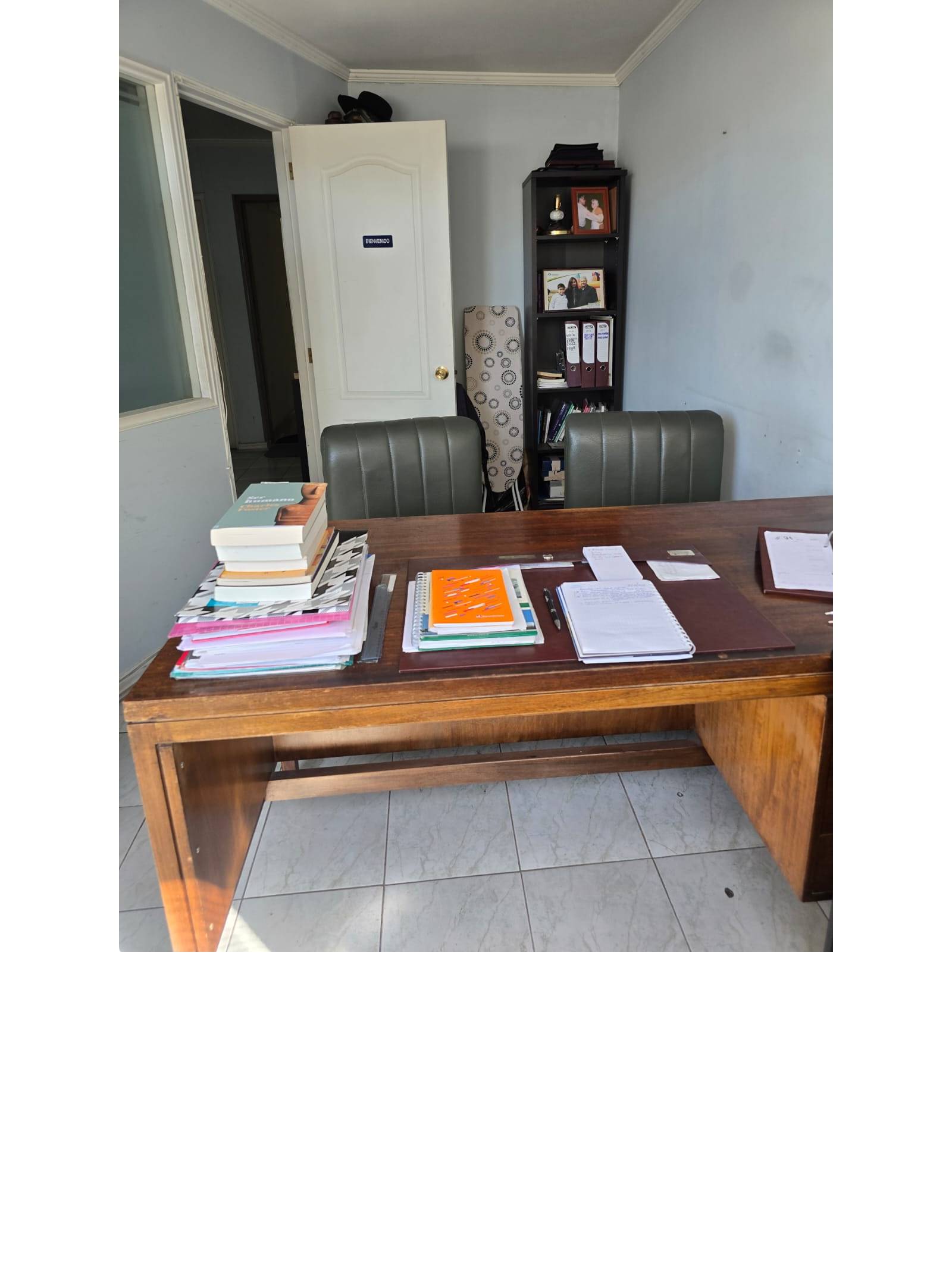 Escritorio ejecutivo con estantería al fondo.