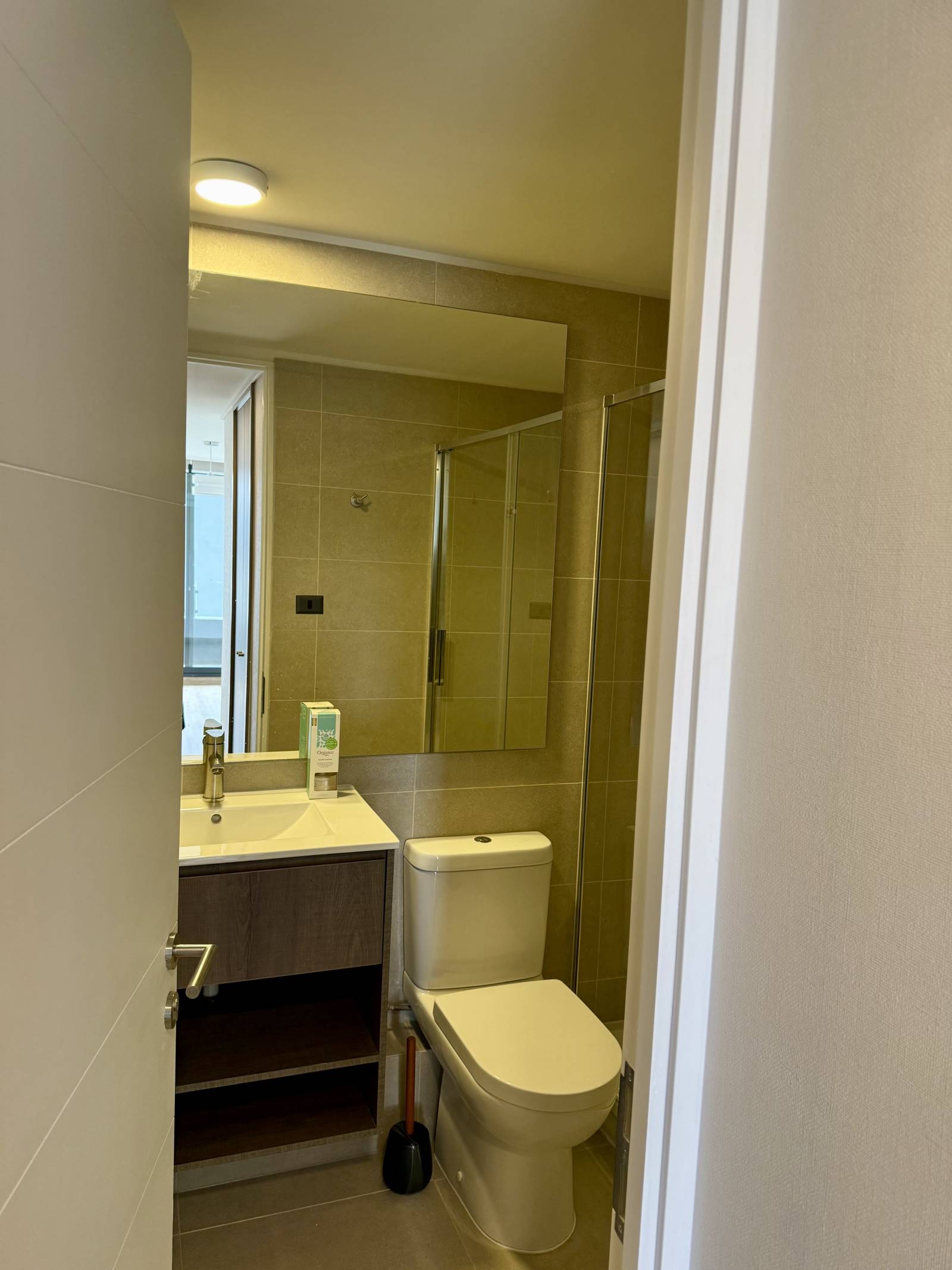 Baño completo con vanitorio moderno, espejo amplio y receptáculo de ducha.