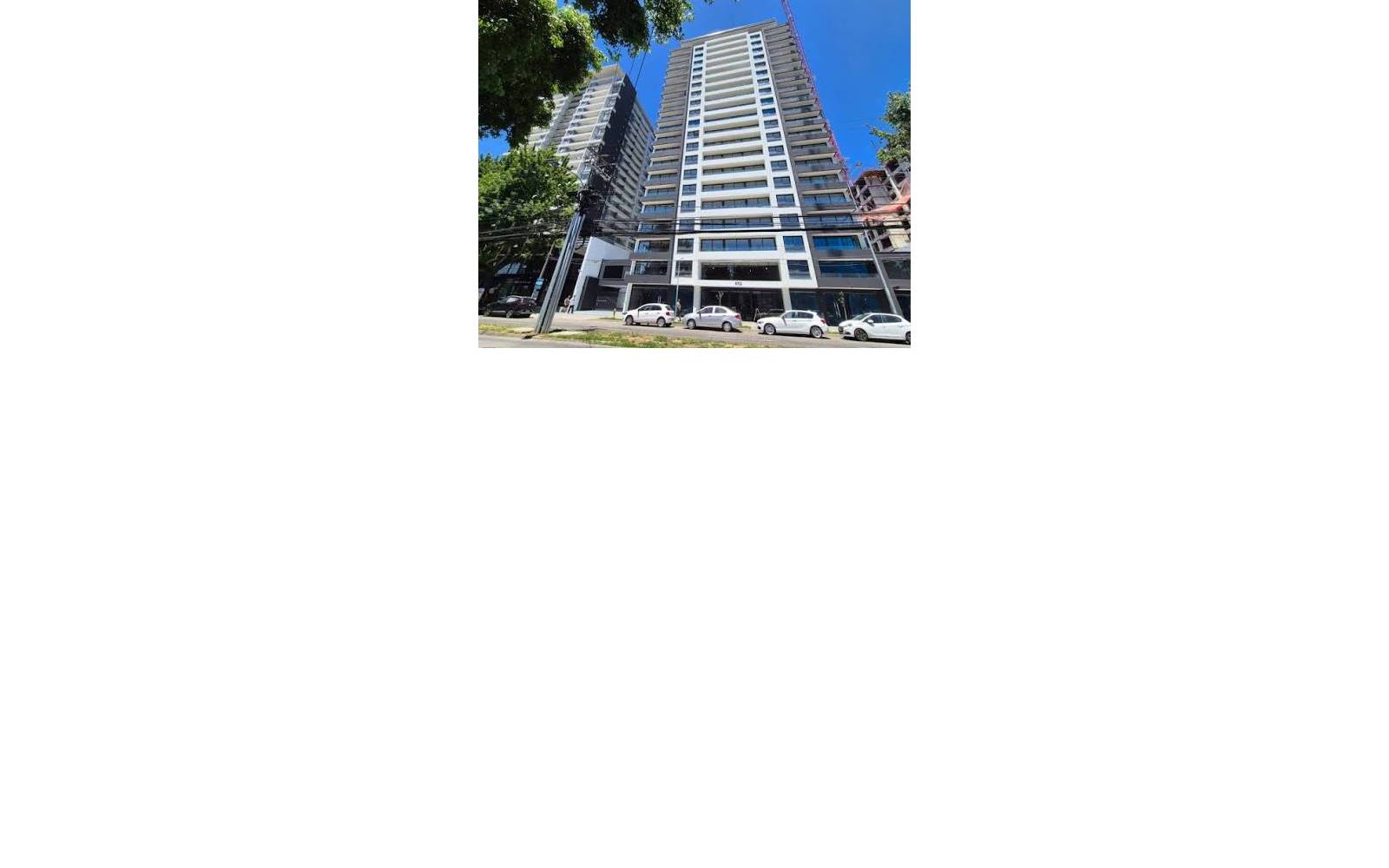 Edificio residencial moderno en esquina con franjas en blanco.