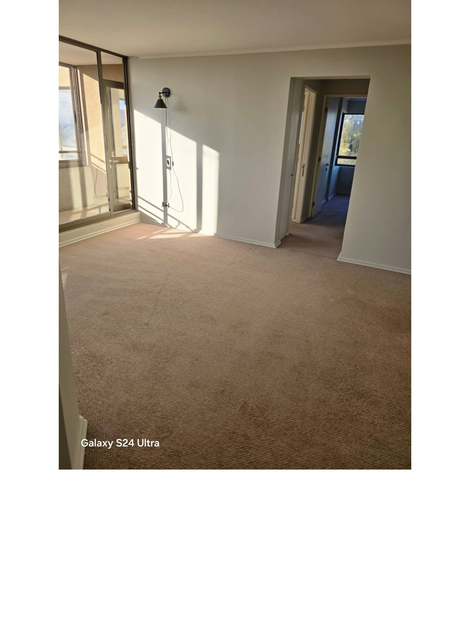 Dormitorio alfombrado vacío con pasillo hacia otros ambientes