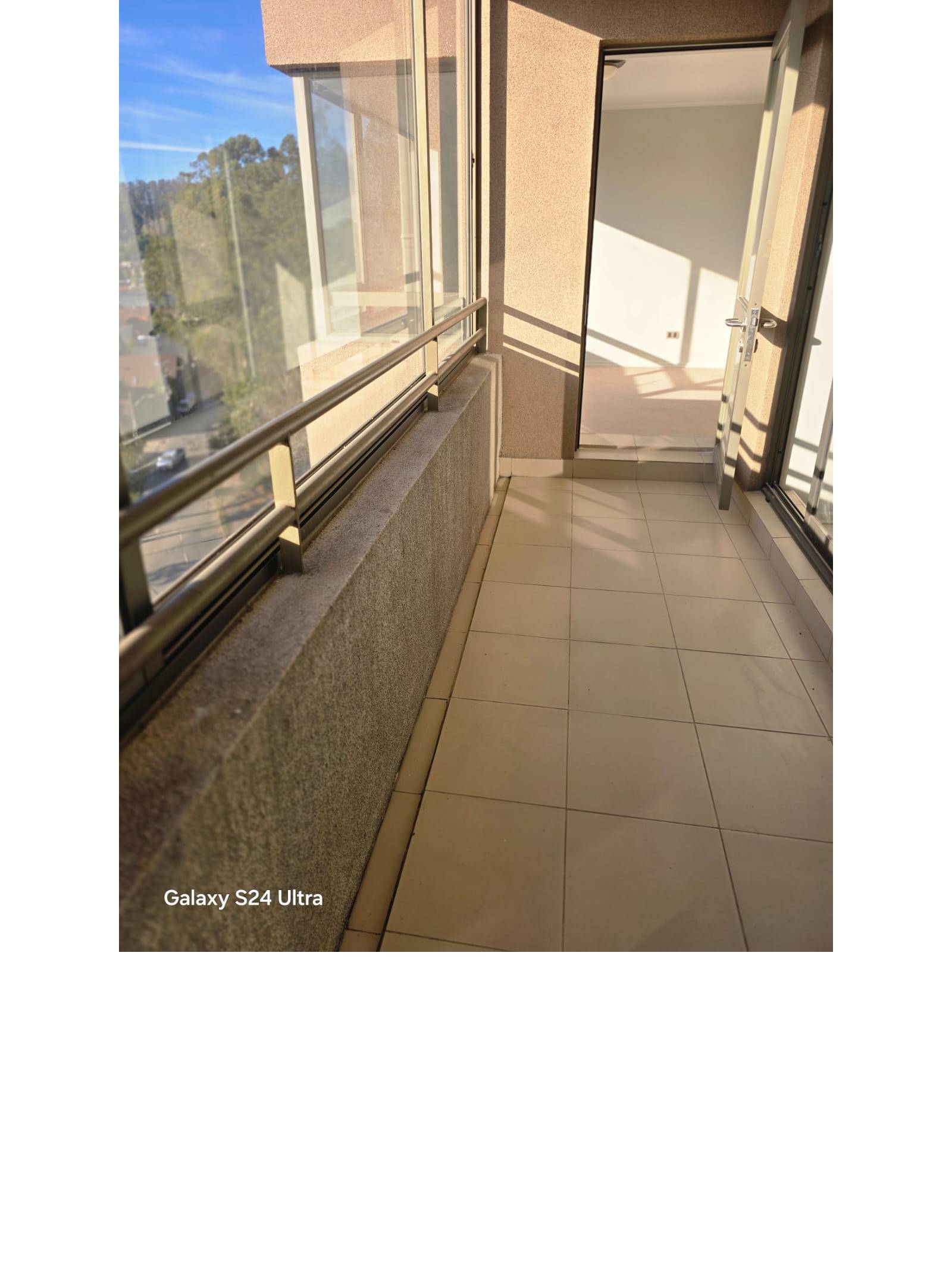 Balcón alargado con piso cerámico y vista exterior soleada