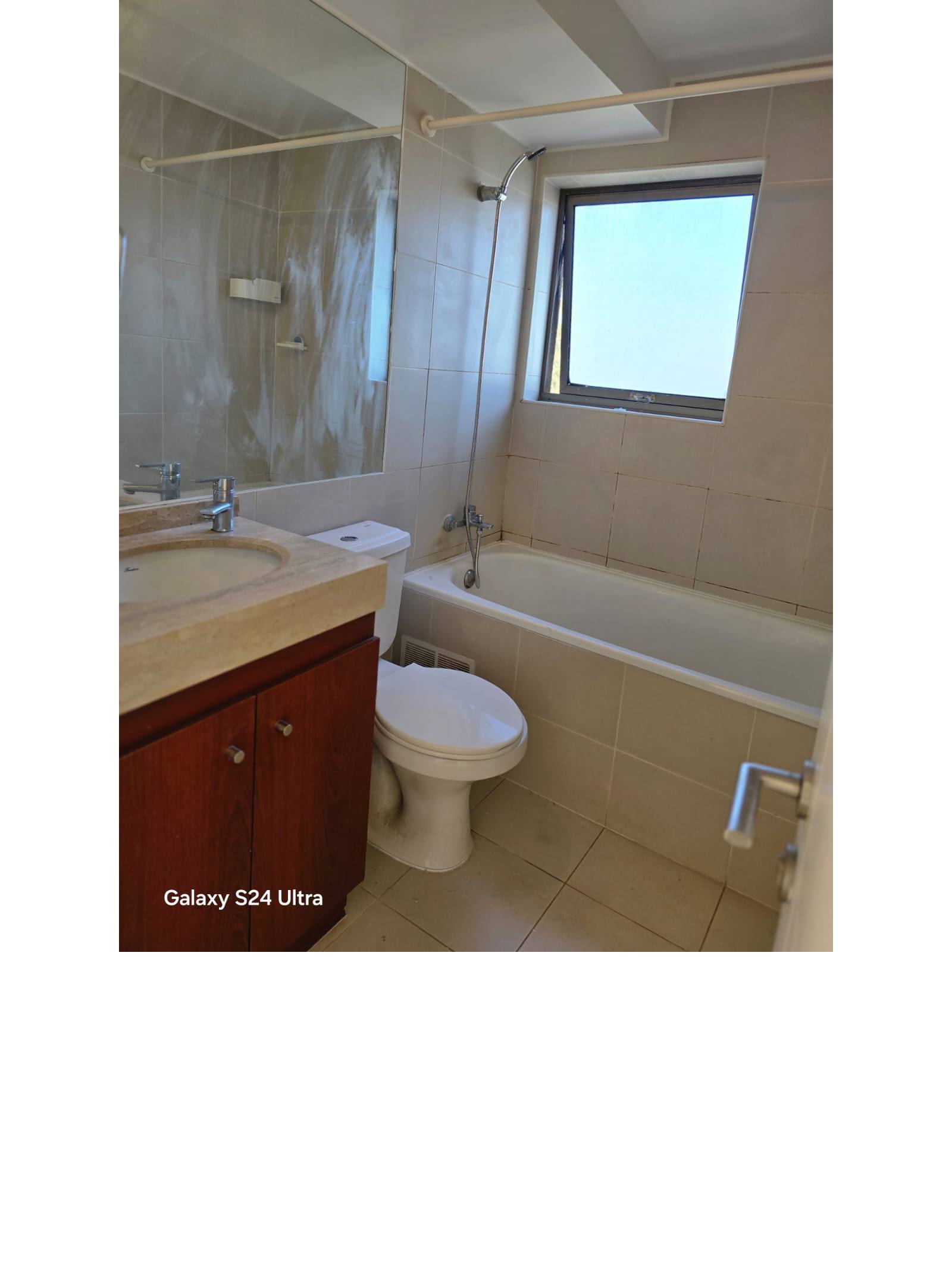 Baño con vanitorio de mármol, tina y ventana exterior