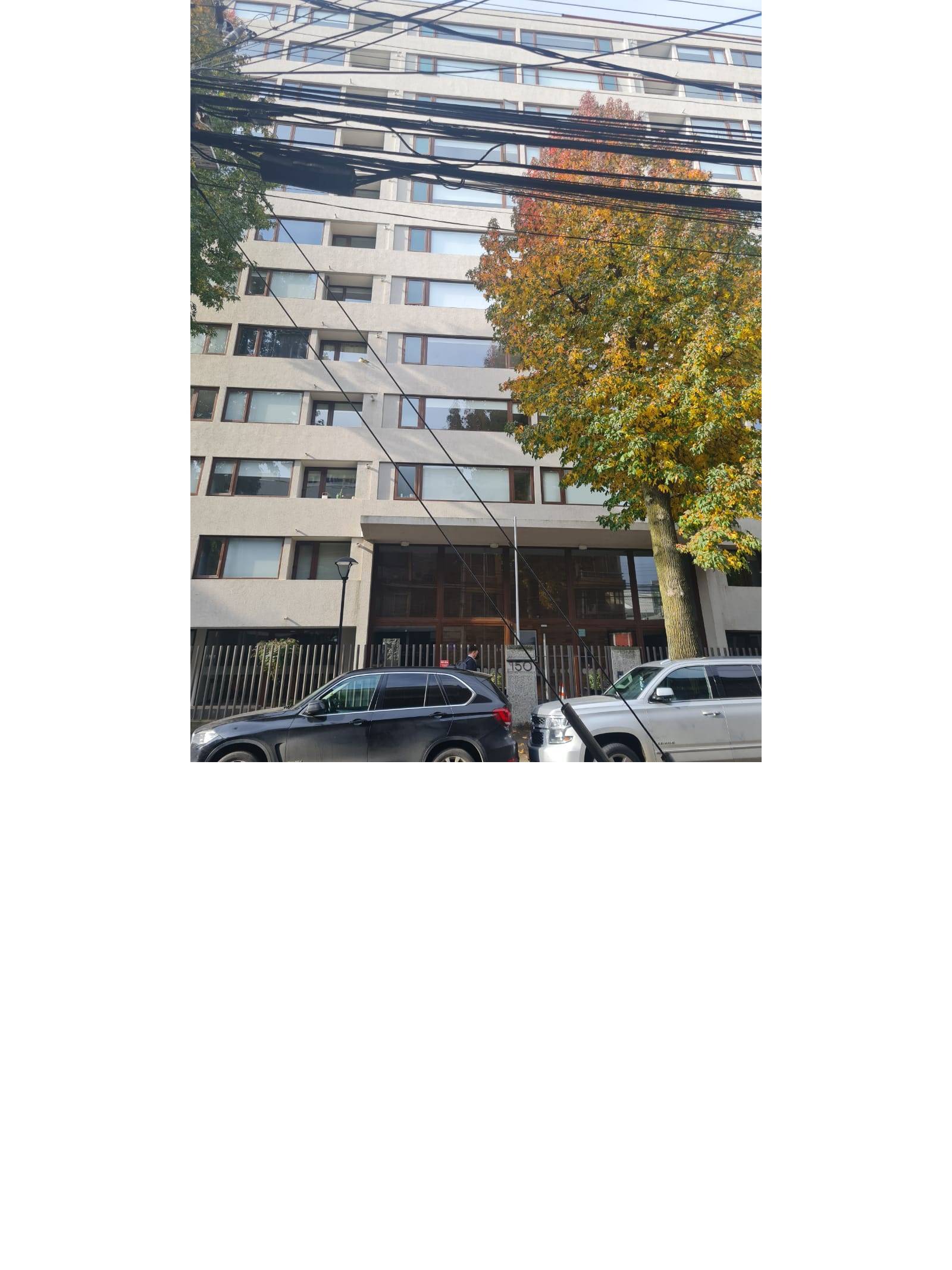 Fachada del edificio residencial con árboles al frente.