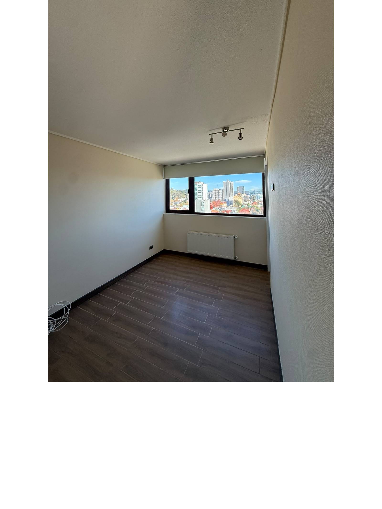 Dormitorio con piso flotante, calefactor y ventana panorámica.