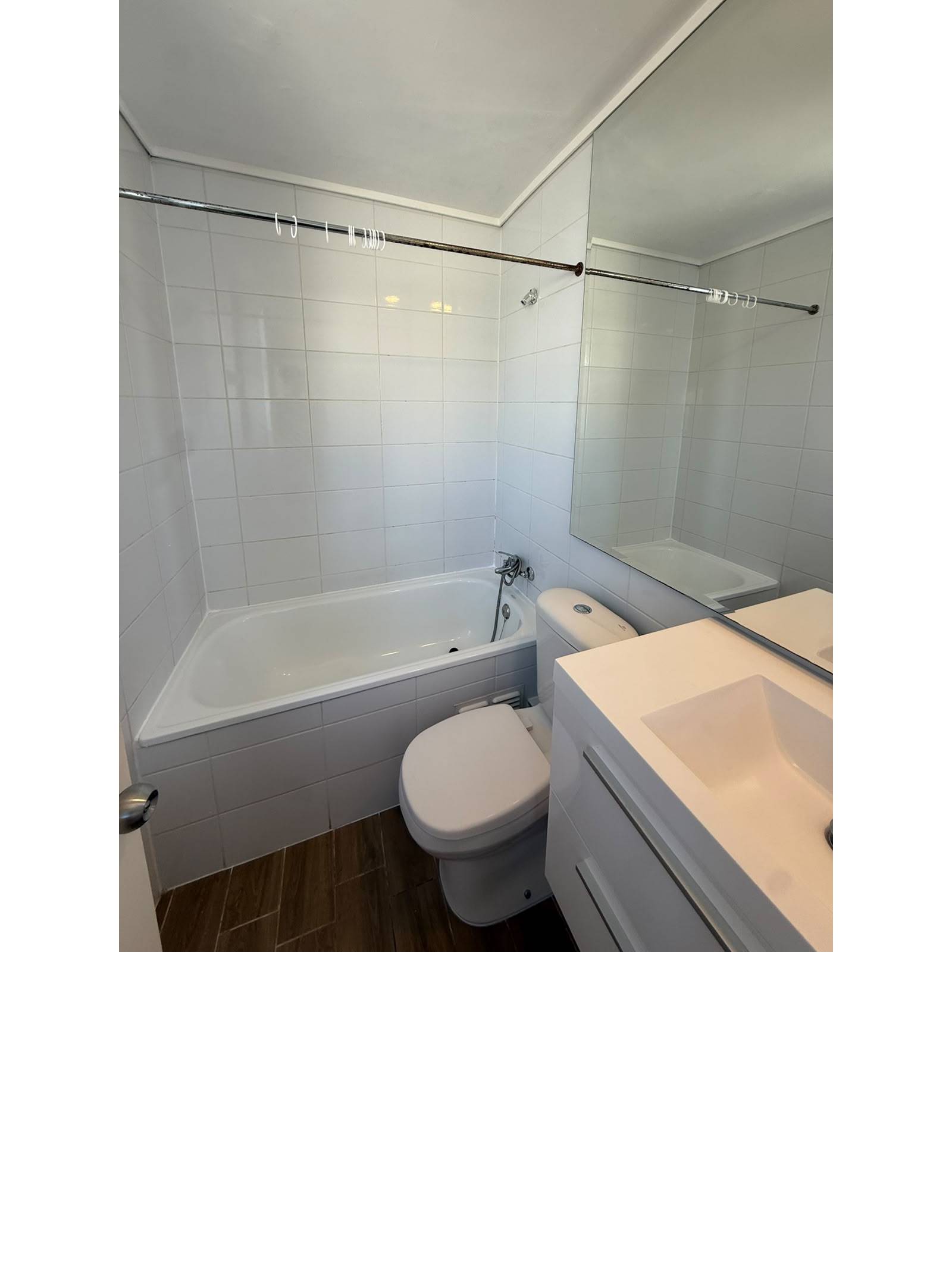 Baño completo con tina, vanitorio y espejo amplio.