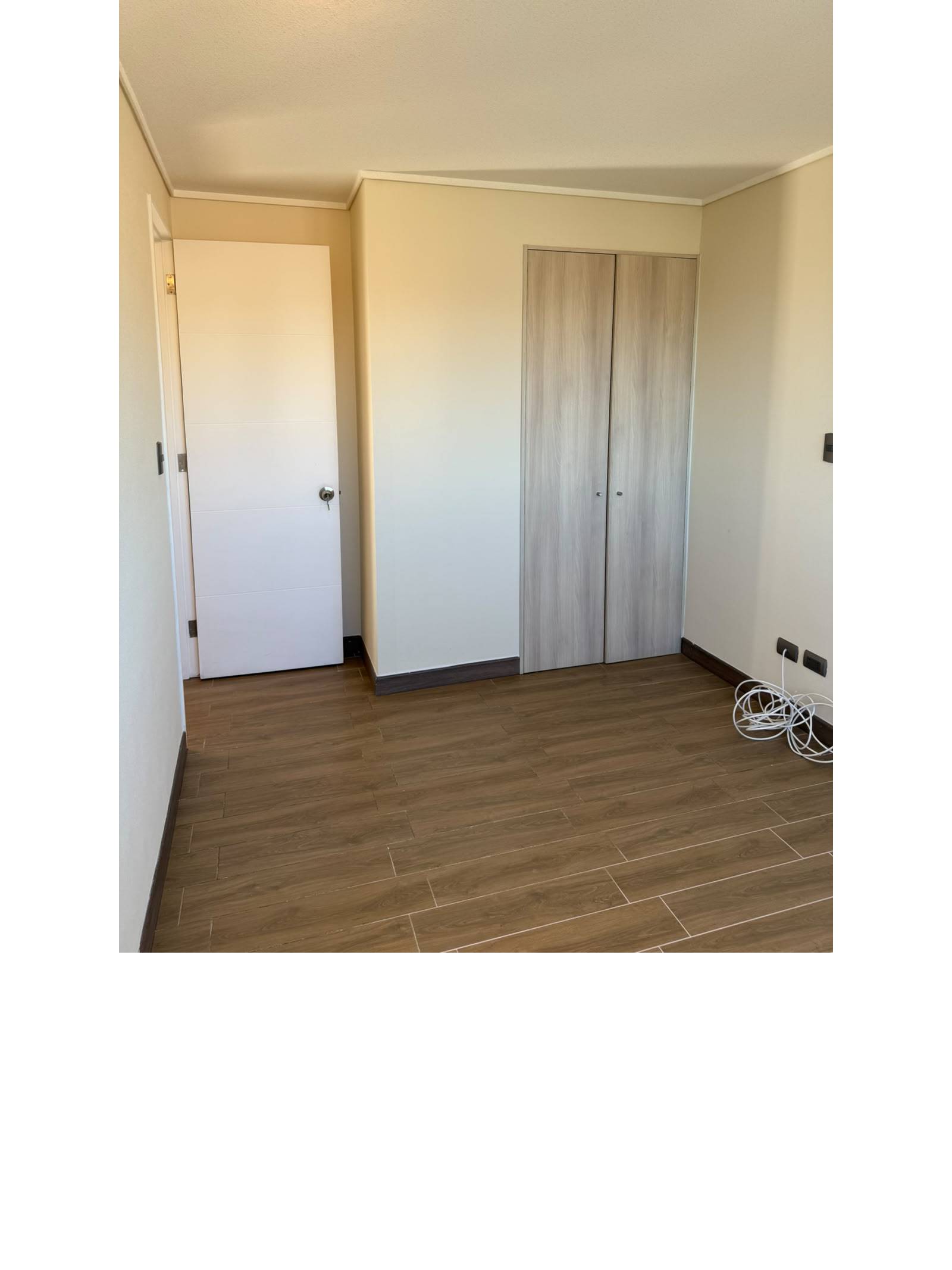 Dormitorio vacío con clóset empotrado y puerta blanca.