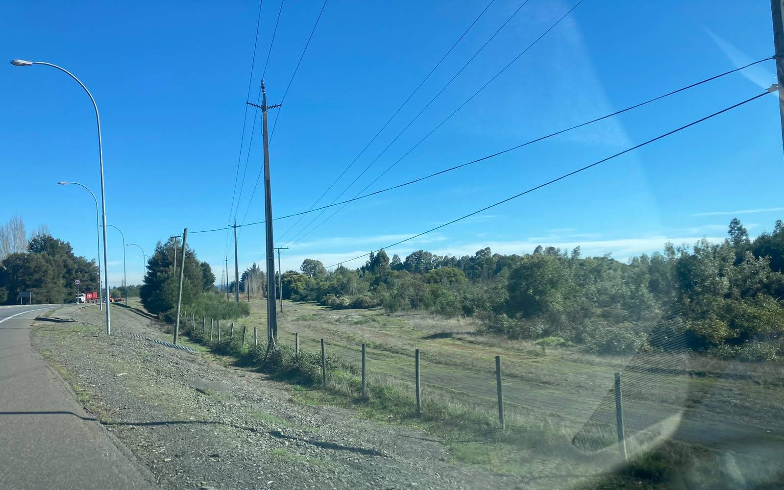 Vista del predio desde carretera con postes de luz
