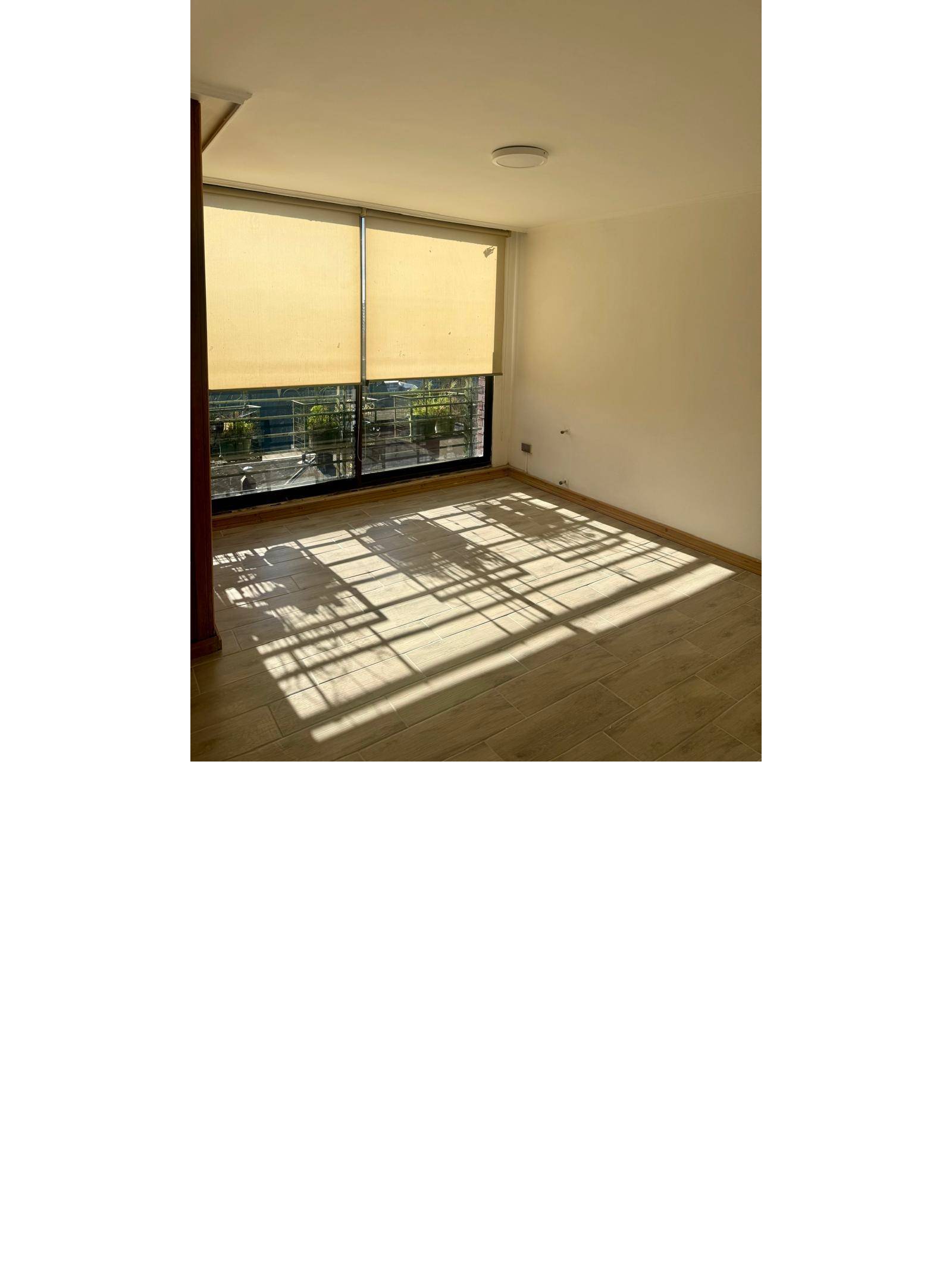 Zona de estar o comedor con amplio ventanal y cortinas roller.
