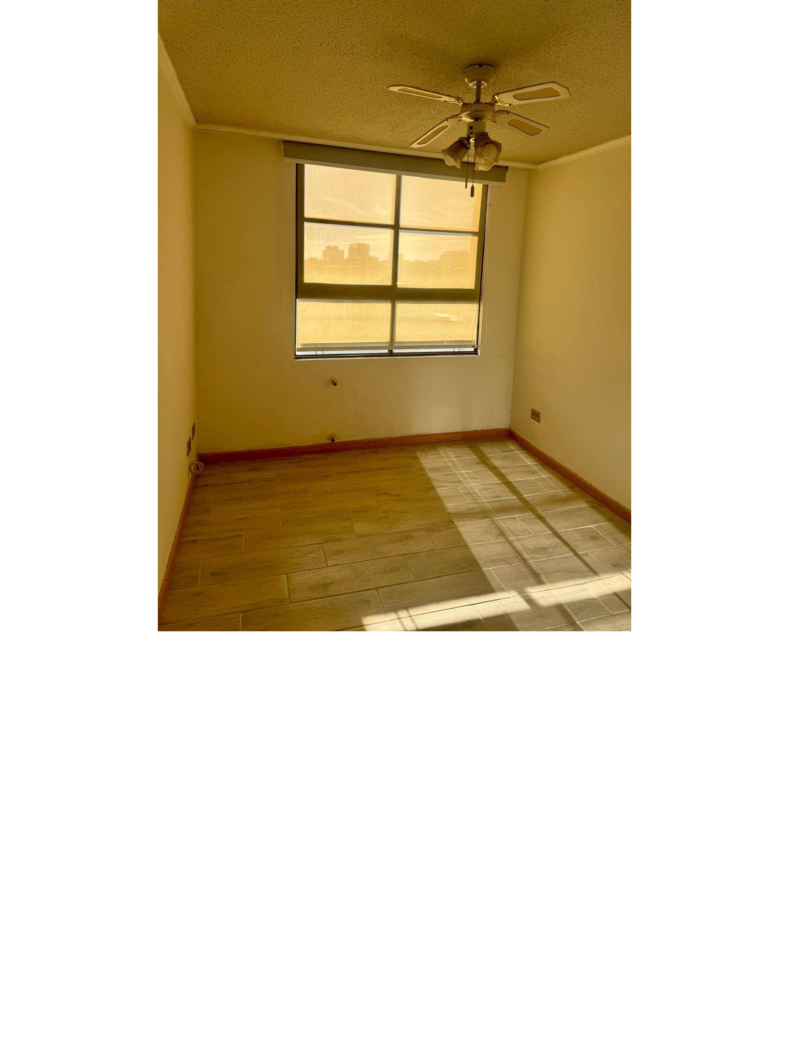 Dormitorio con ventilador de techo y ventana con buena entrada de luz.