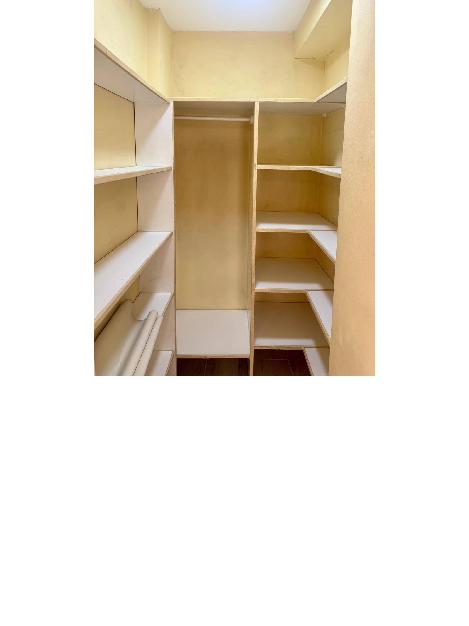 Walk-in closet con repisas y barra para colgar ropa.