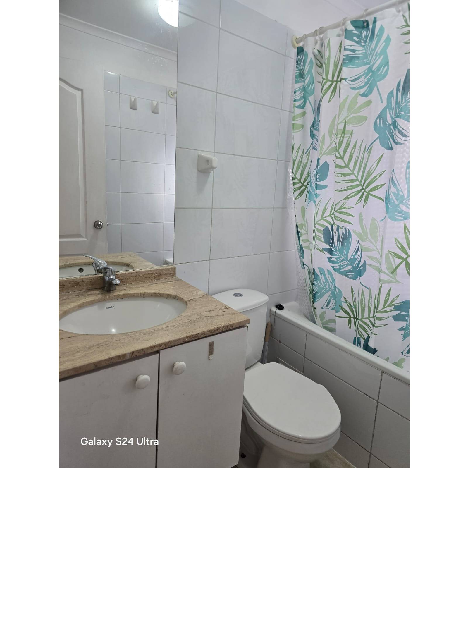 Baño principal con vanitorio de mármol, tina y cortina estampada