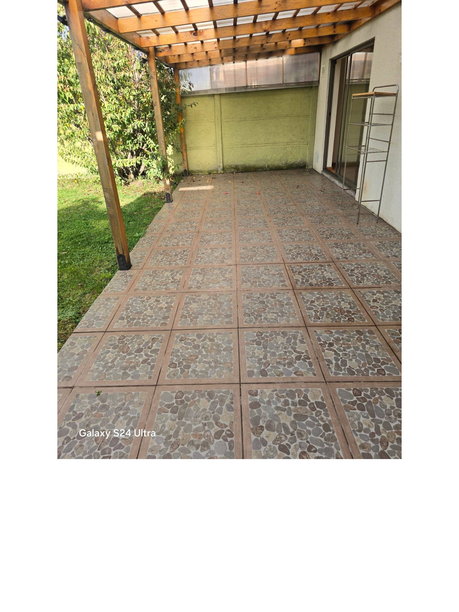 Terraza techada con pérgola de madera y baldosas de piedra