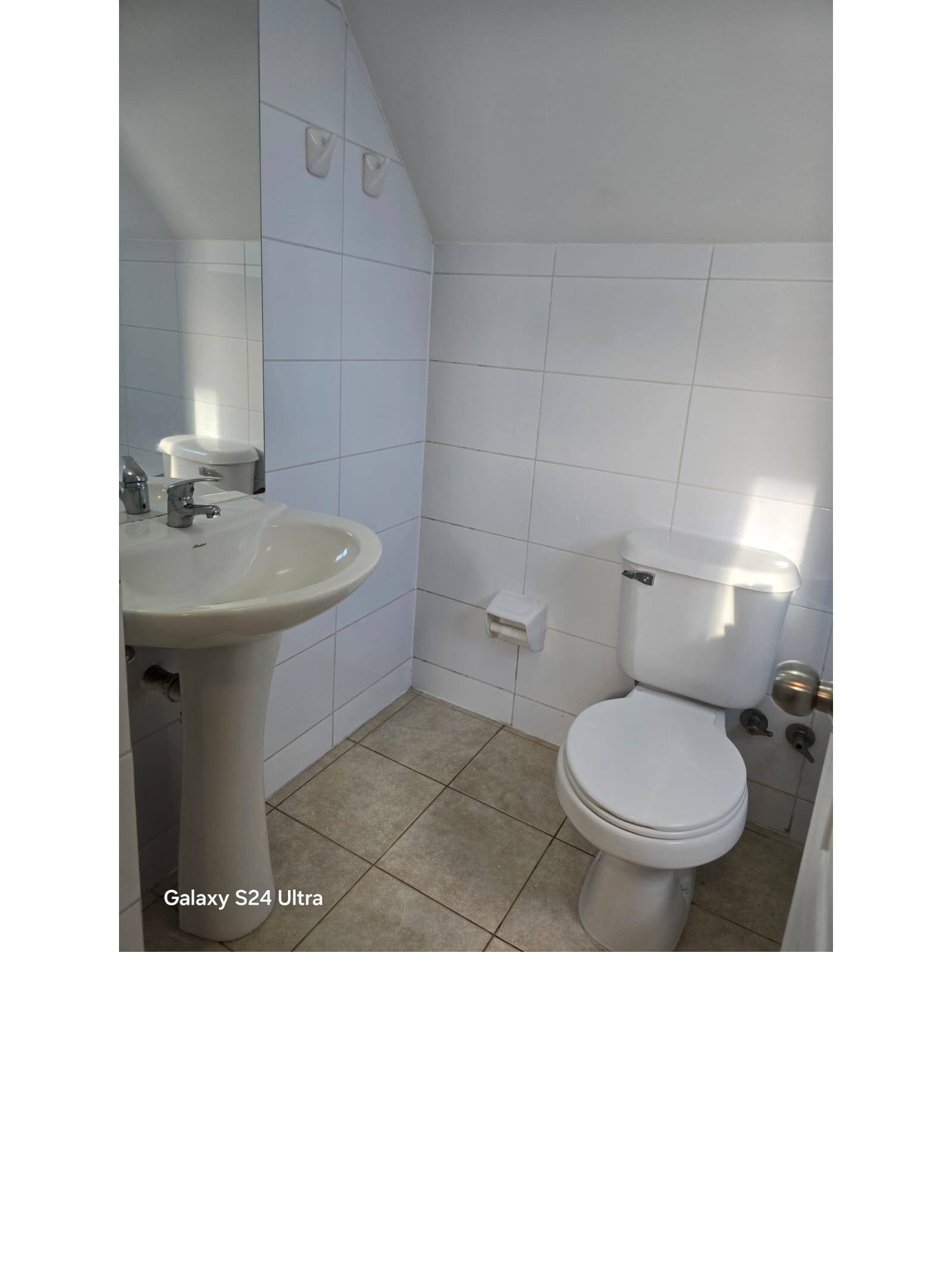 Baño secundario en segundo piso con lavamanos e inodoro