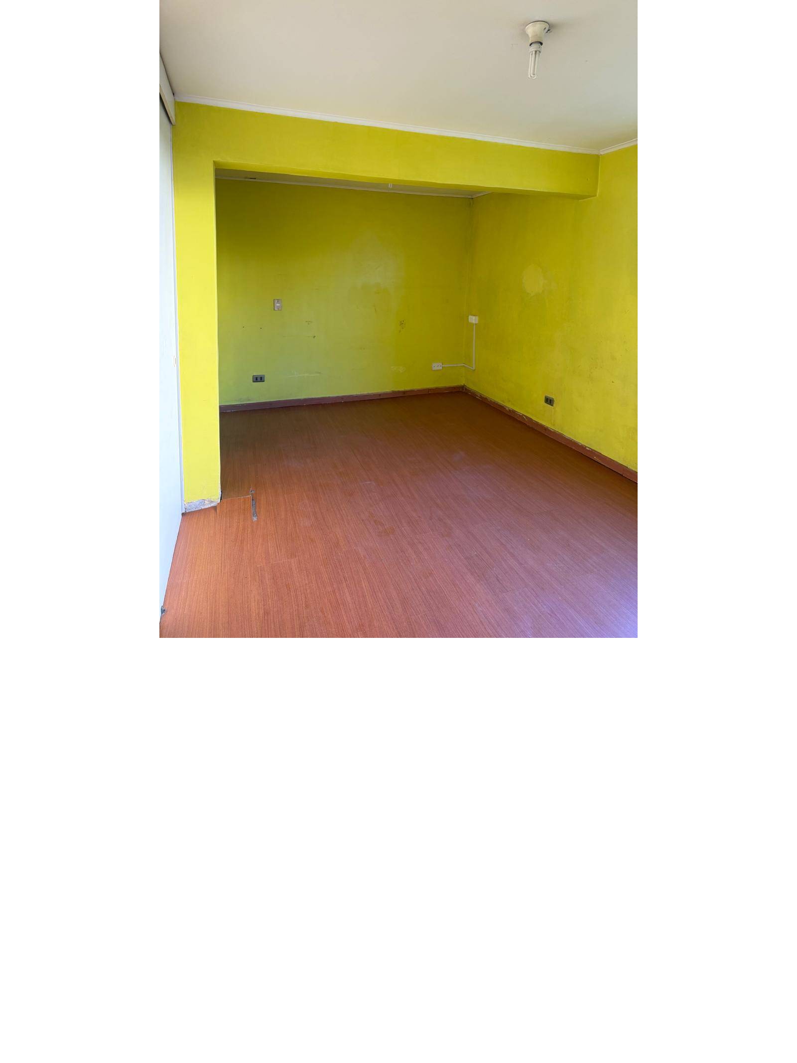 Dormitorio espacioso con muros verdes y piso flotante.