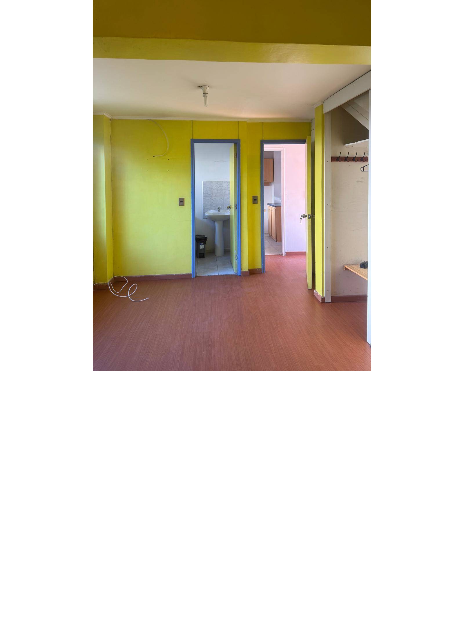Área común con acceso a baño y otras habitaciones.