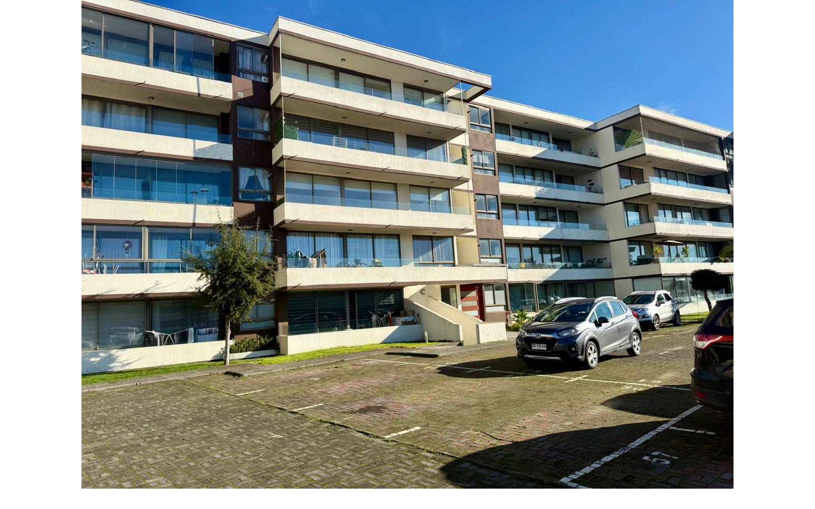Fachada del edificio residencial y estacionamientos exteriores