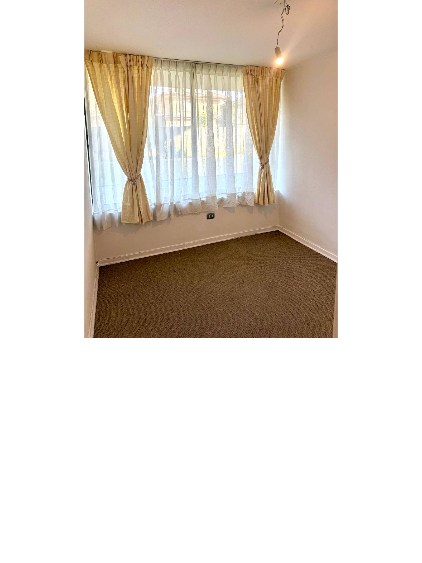 Dormitorio con ventanal amplio y piso alfombrado