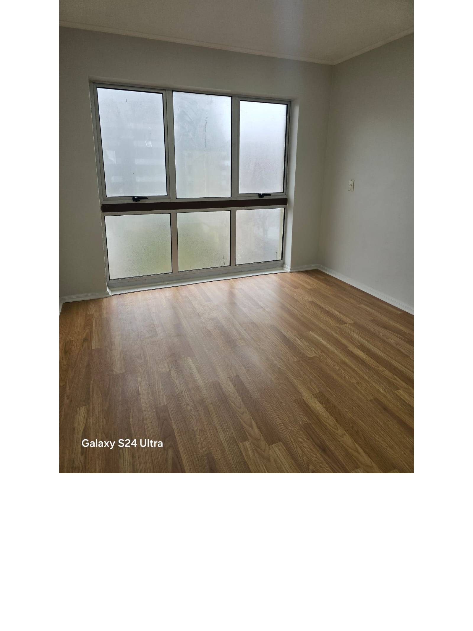 Dormitorio luminoso con piso flotante y ventanal amplio