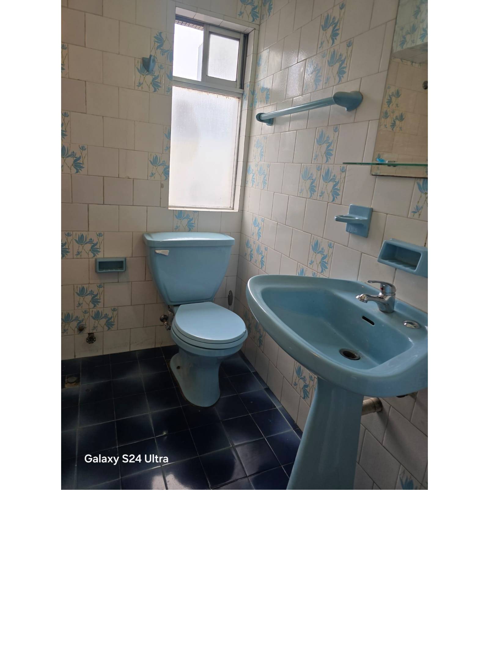 Baño con artefactos celestes y revestimiento cerámico
