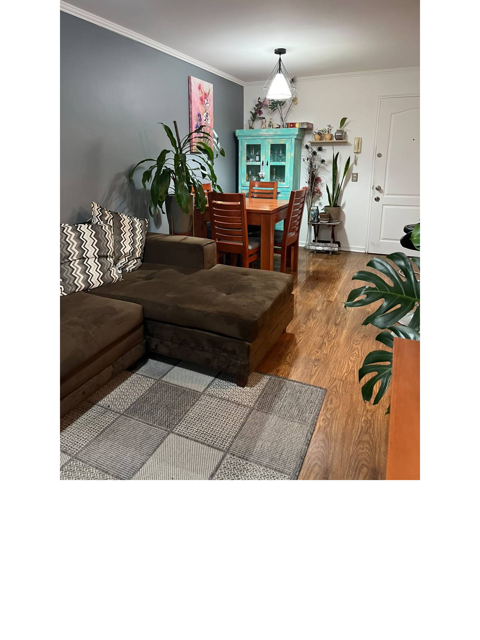 Comedor de madera con mueble vitrina turquesa y sofá seccional