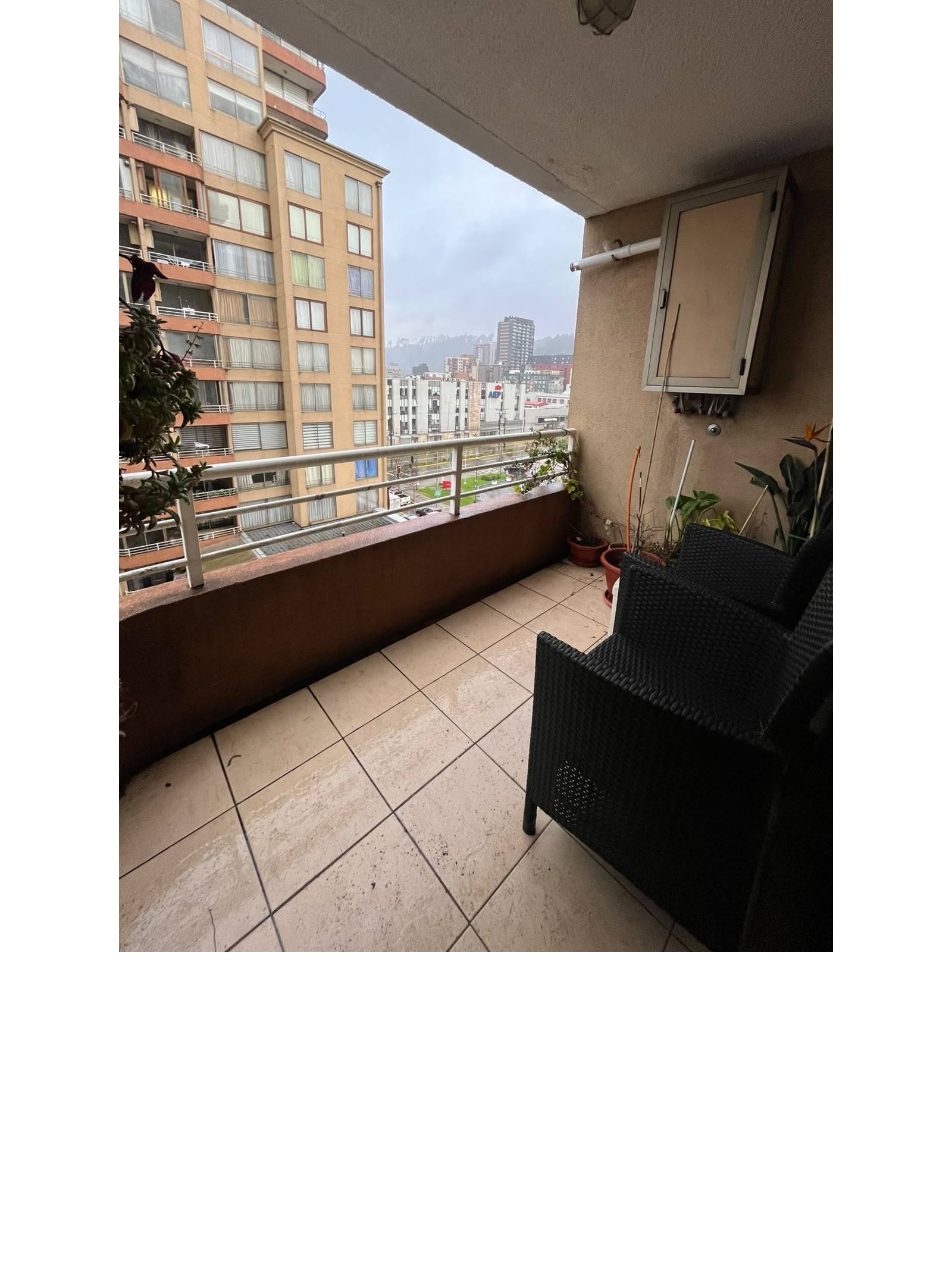 Terraza con sillones de mimbre y vista despejada a la ciudad