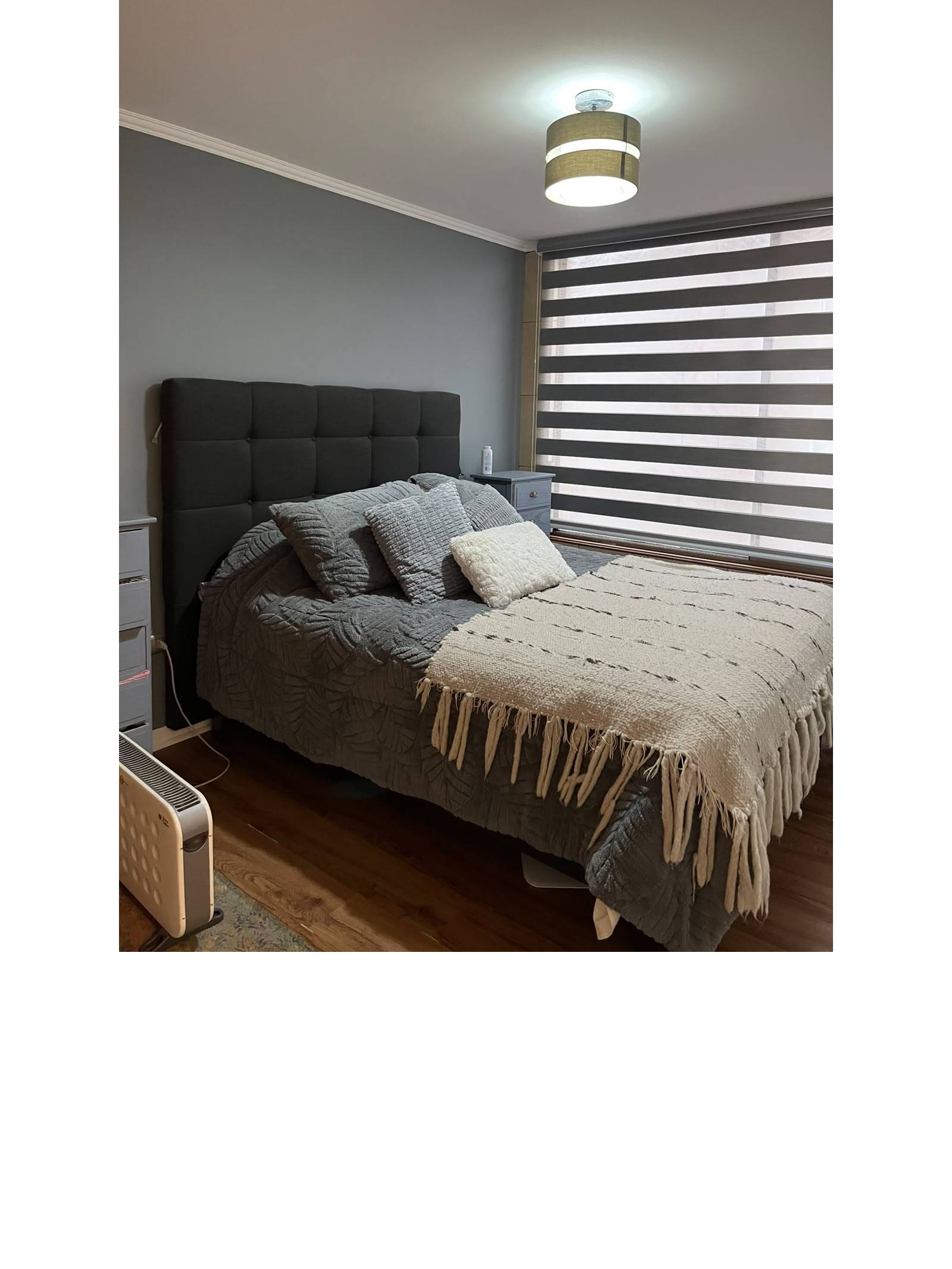 Dormitorio principal con cama matrimonial y respaldo tapizado gris