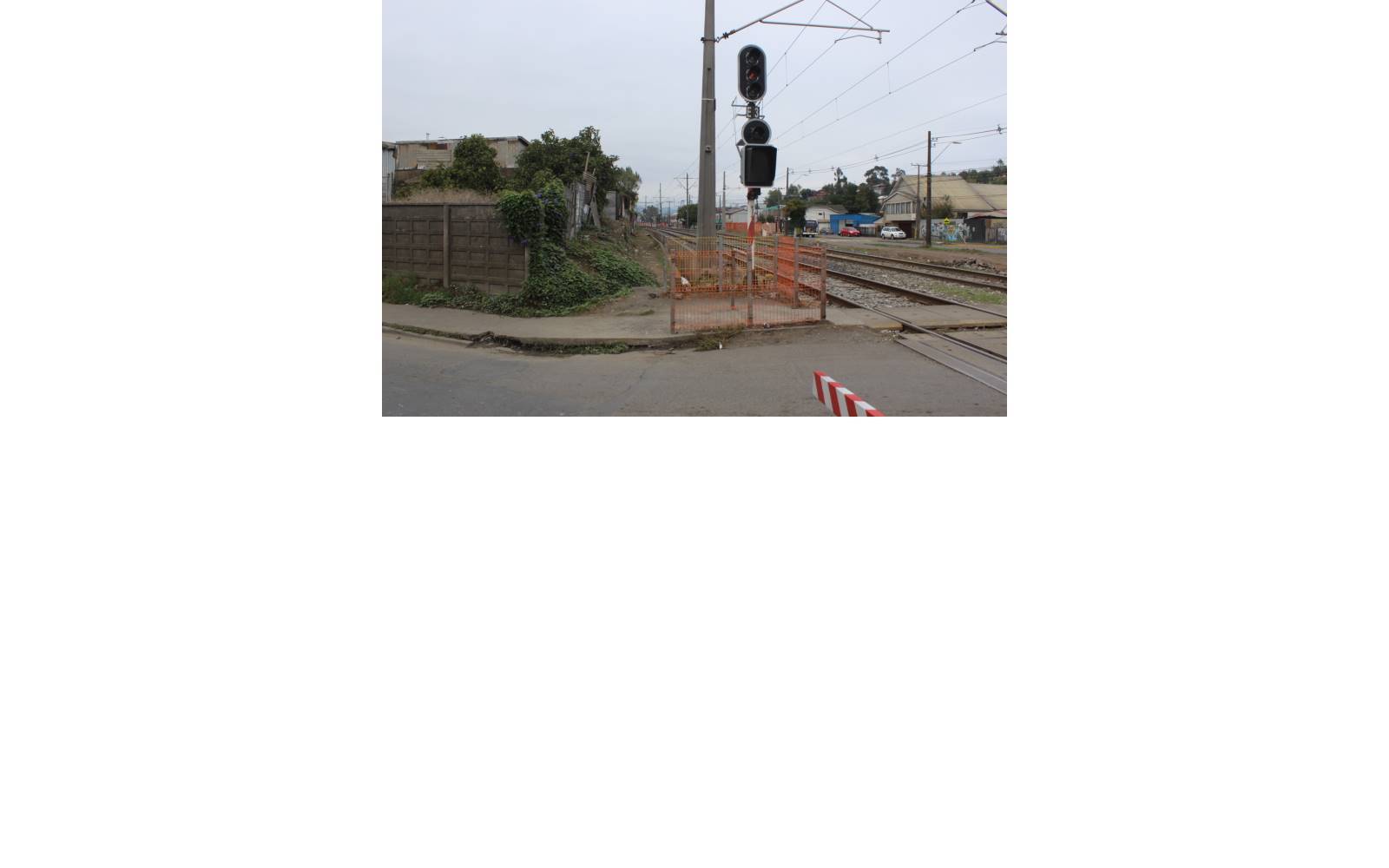 Cruce ferroviario con señalética y vía férrea adyacente