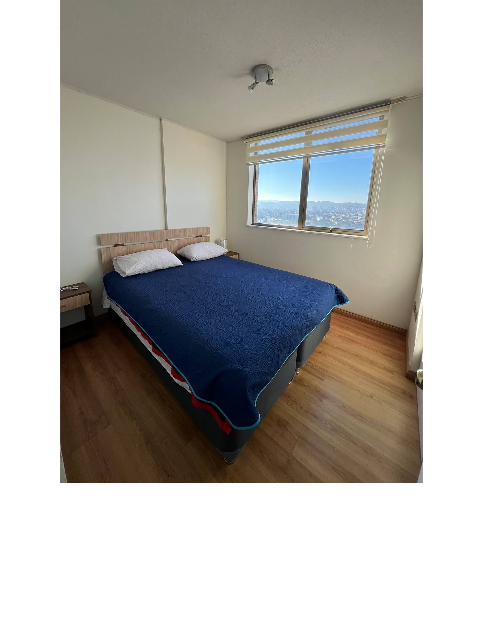 Dormitorio principal con cama dos plazas y ventana con vista abierta.