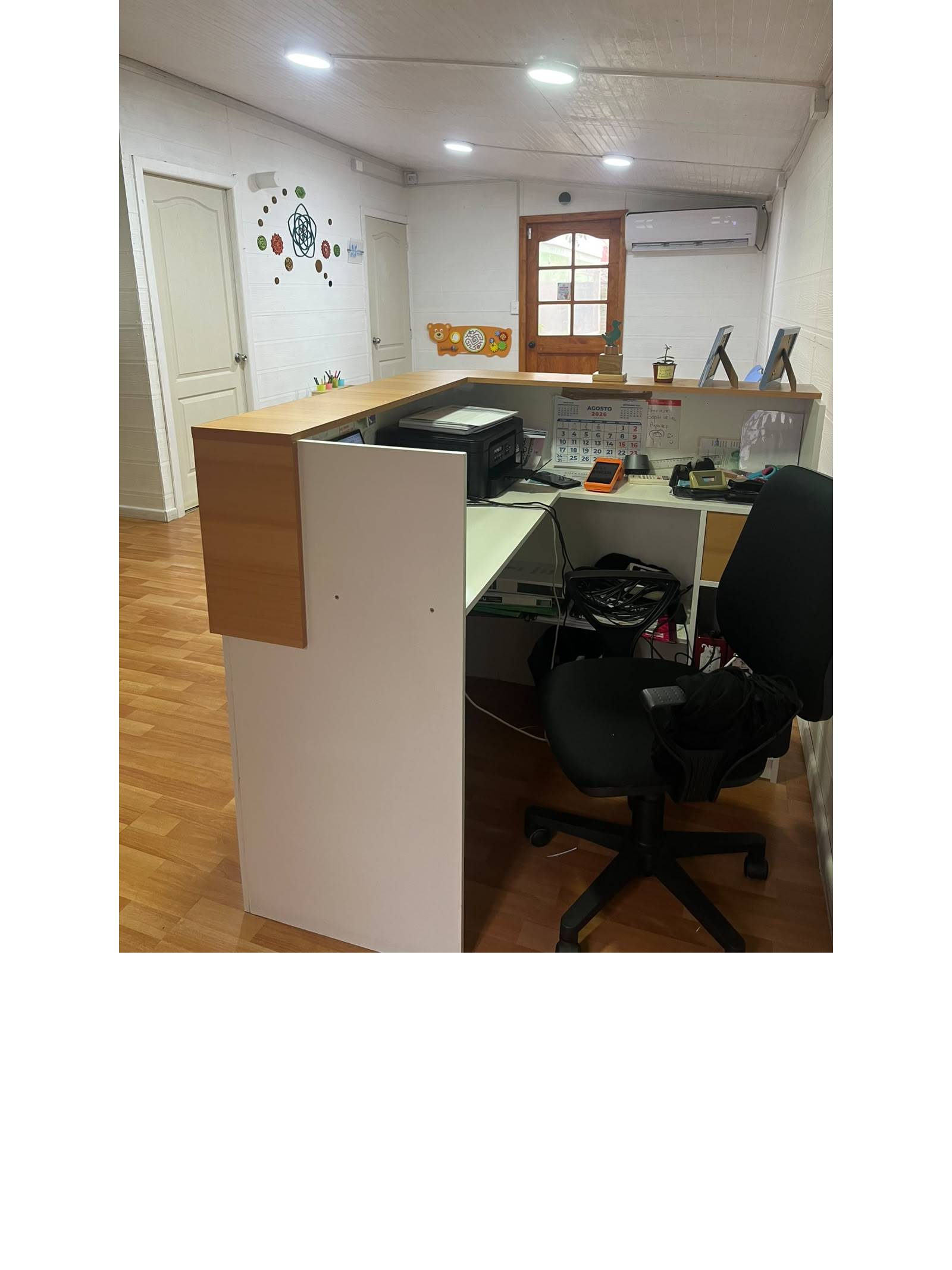 Recepción y oficina equipada con escritorio y aire acondicionado.
