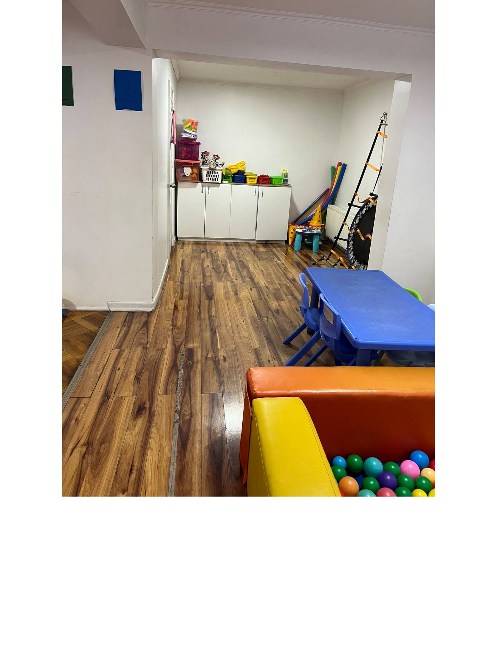 Sala infantil de juegos con muebles organizadores y piso vinílico.