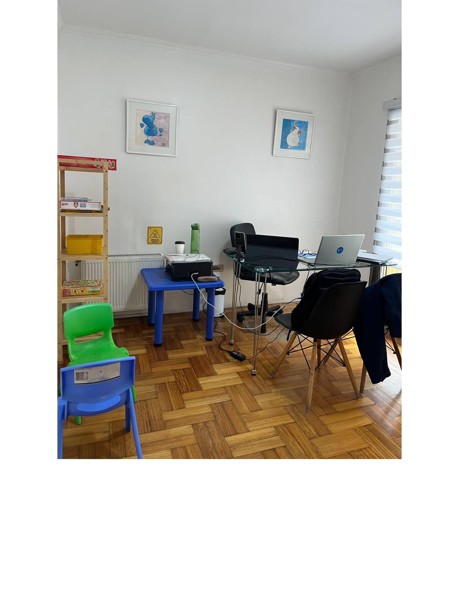Oficina privada con escritorios, laptops y piso de madera.