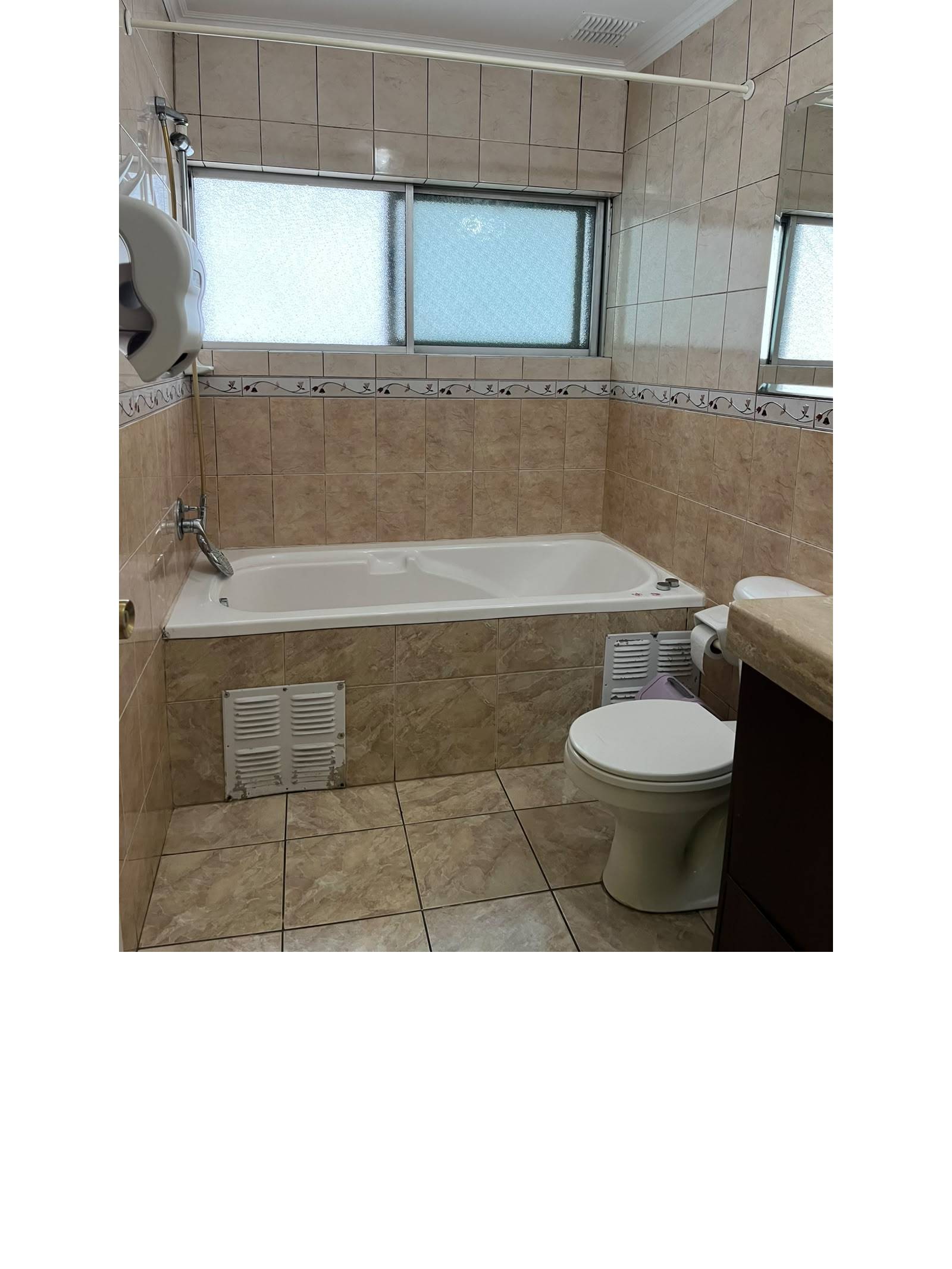 Baño completo con tina, revestimiento cerámico y ventana exterior.