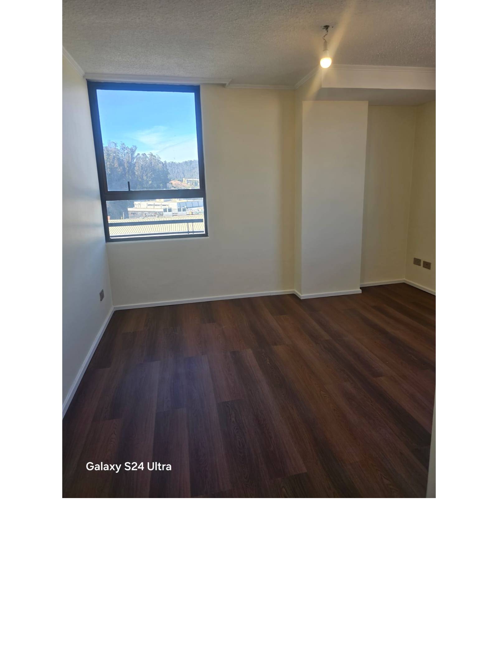 Dormitorio vacío con ventana y pisos flotantes de madera
