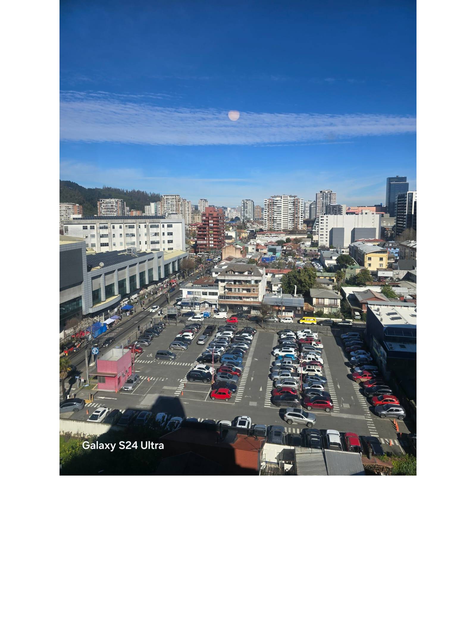 Vista alta hacia estacionamiento exterior y sector urbano