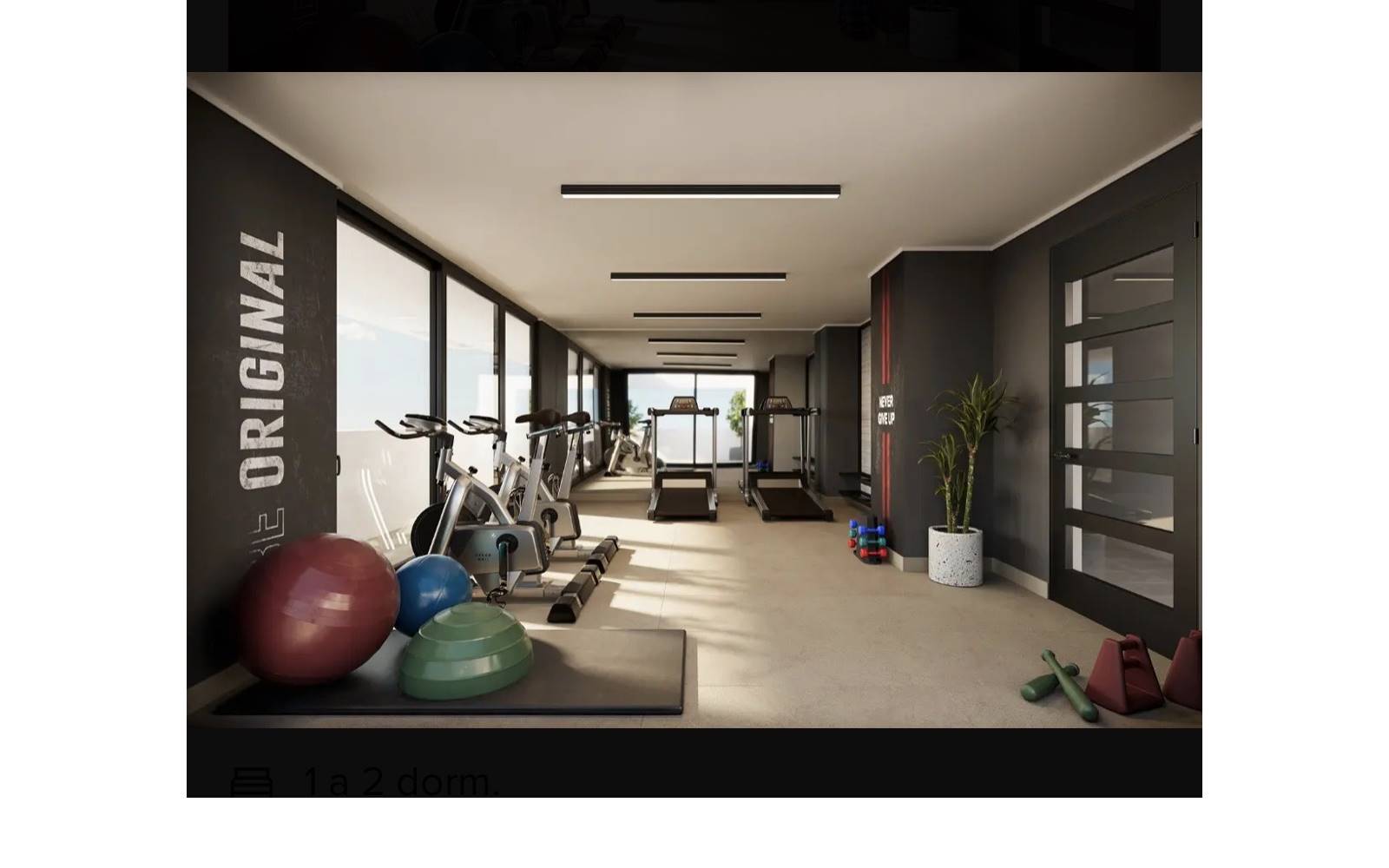 Gimnasio equipado del edificio con trotadoras y bicicletas estáticas.