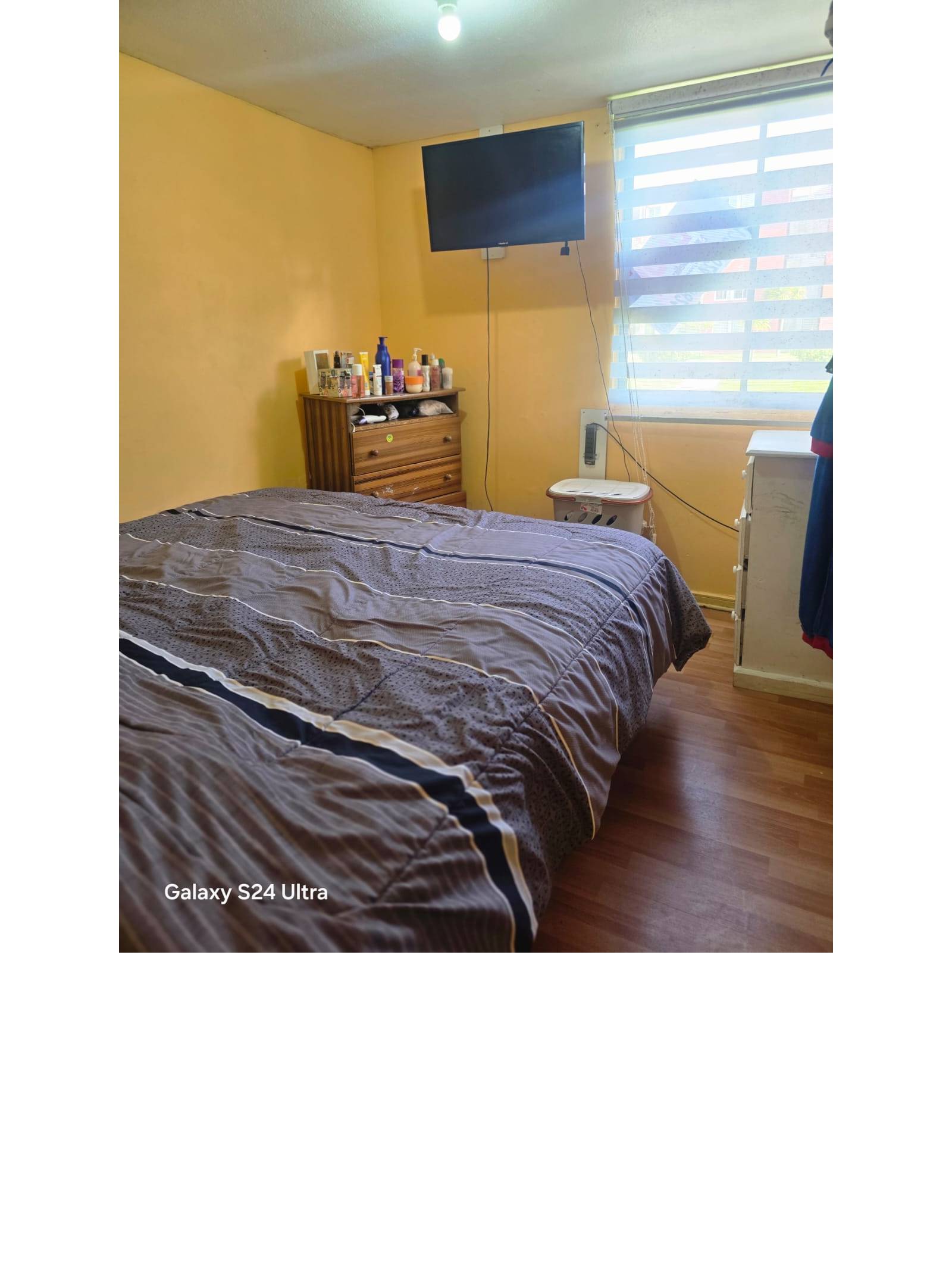 Dormitorio principal con cama matrimonial y televisión.
