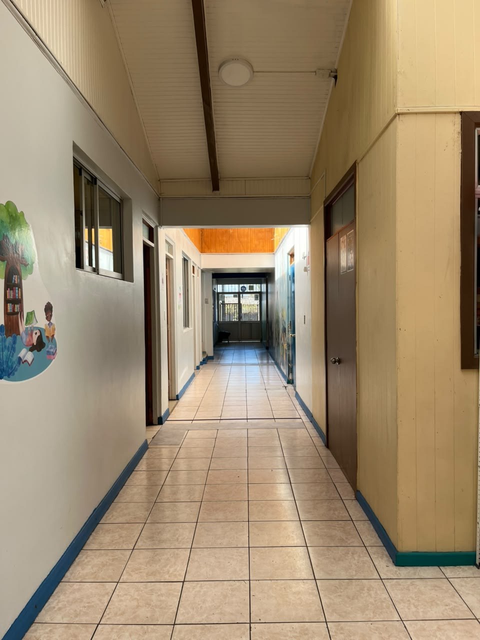 Pasillo largo con piso cerámico y puertas a ambos lados