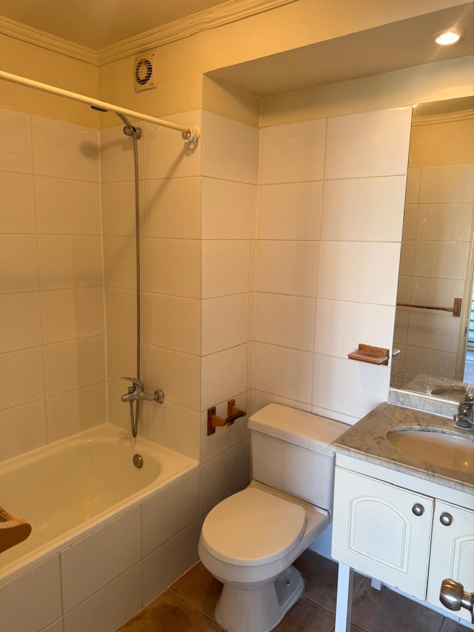 Baño completo con tina, vanitorio y muros cerámicos