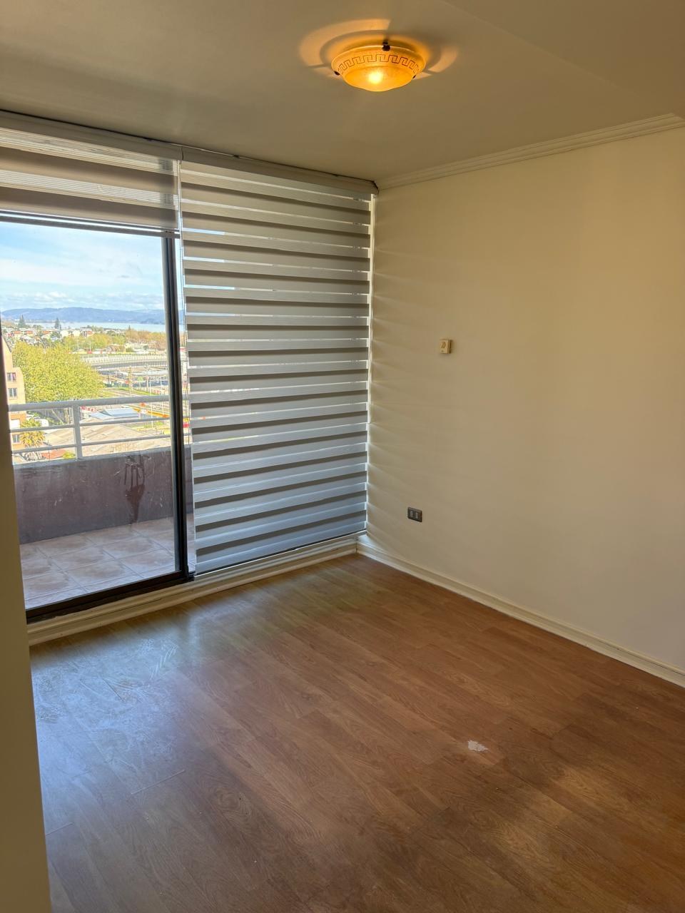Dormitorio con piso flotante y ventanal hacia el balcón