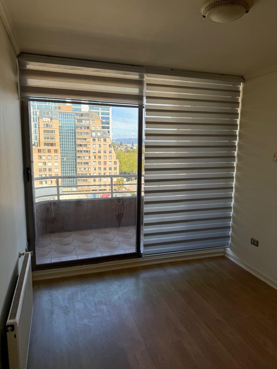 Habitación con persianas roller y salida al balcón
