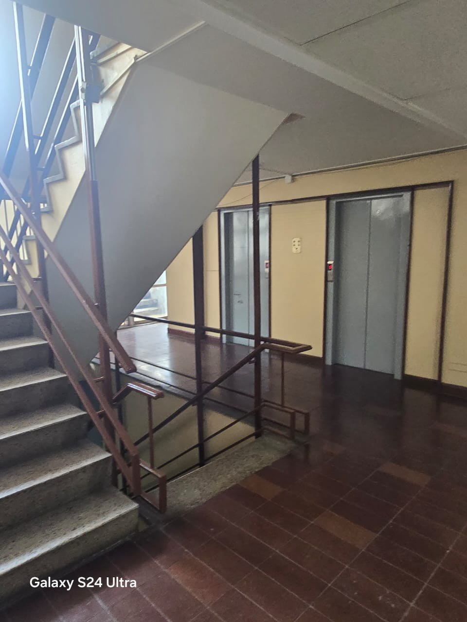 Descanso común con ascensores y escalera en piso del edificio