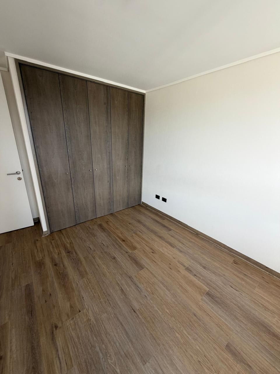 Closet empotrado de madera en dormitorio con piso flotante.